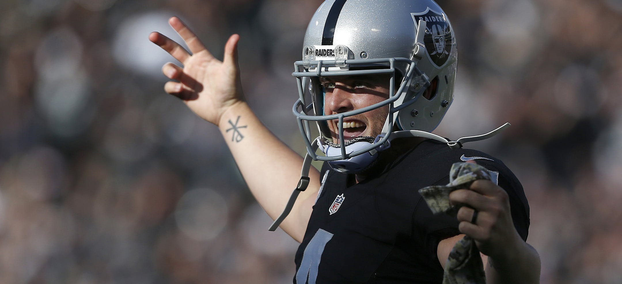 Oakland Raiders quarterback Derek Carr (4) celebrates after throwing a touchdown to wide receiver Andre Holmes during the first half of an NFL football game against the Minnesota Vikings in Oakland, Calif., Sunday, Nov. 15, 2015. (AP Photo/Beck Diefenbach)