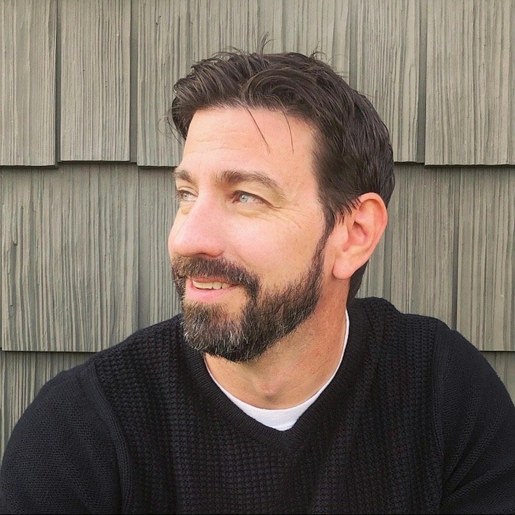photo of author Joe Hart in front of wooden siding