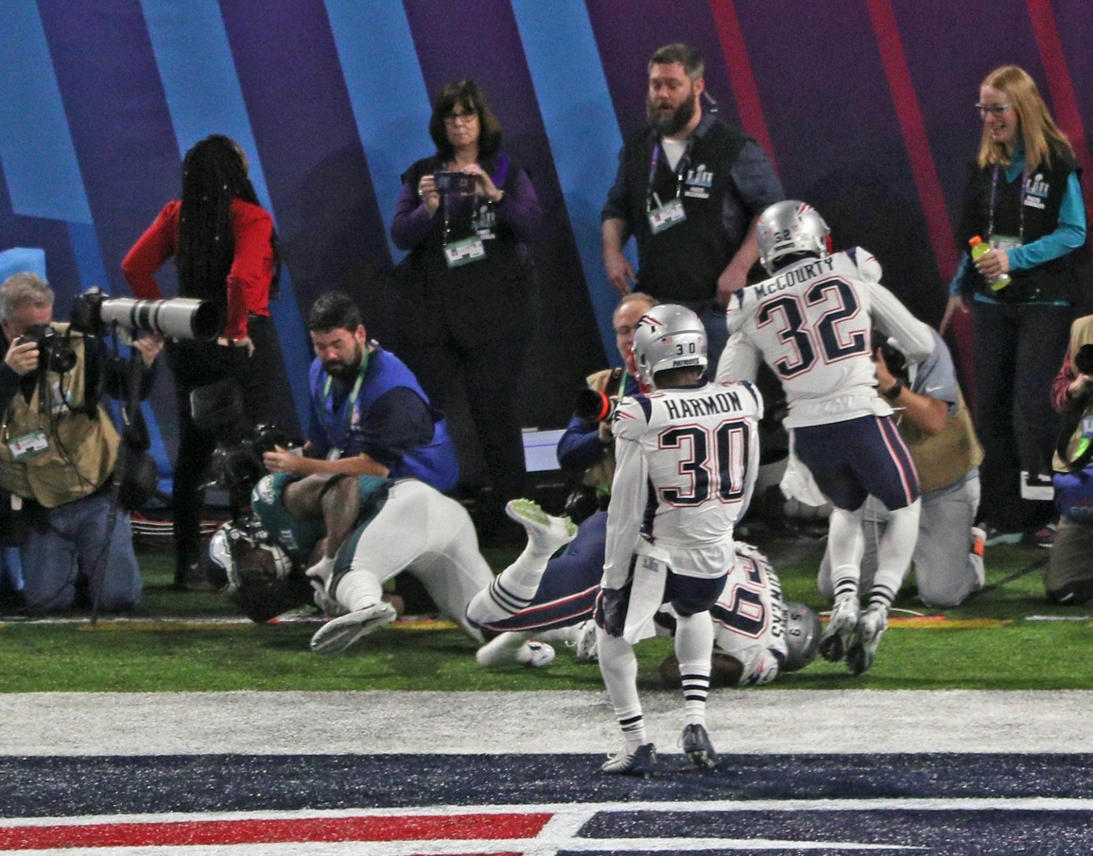 Philadelphia Eagles running back Corey Clement (30), on the ground at left, tumbled out of the end zone after a 22-yard touchdown catch from quarterback Nick Foles in the third quarter of Super Bowl LII. Defending on the play were Duoin Harmon (30), Devin McCourty (32) and Marquis Flowers (59) of the New England Patriots.