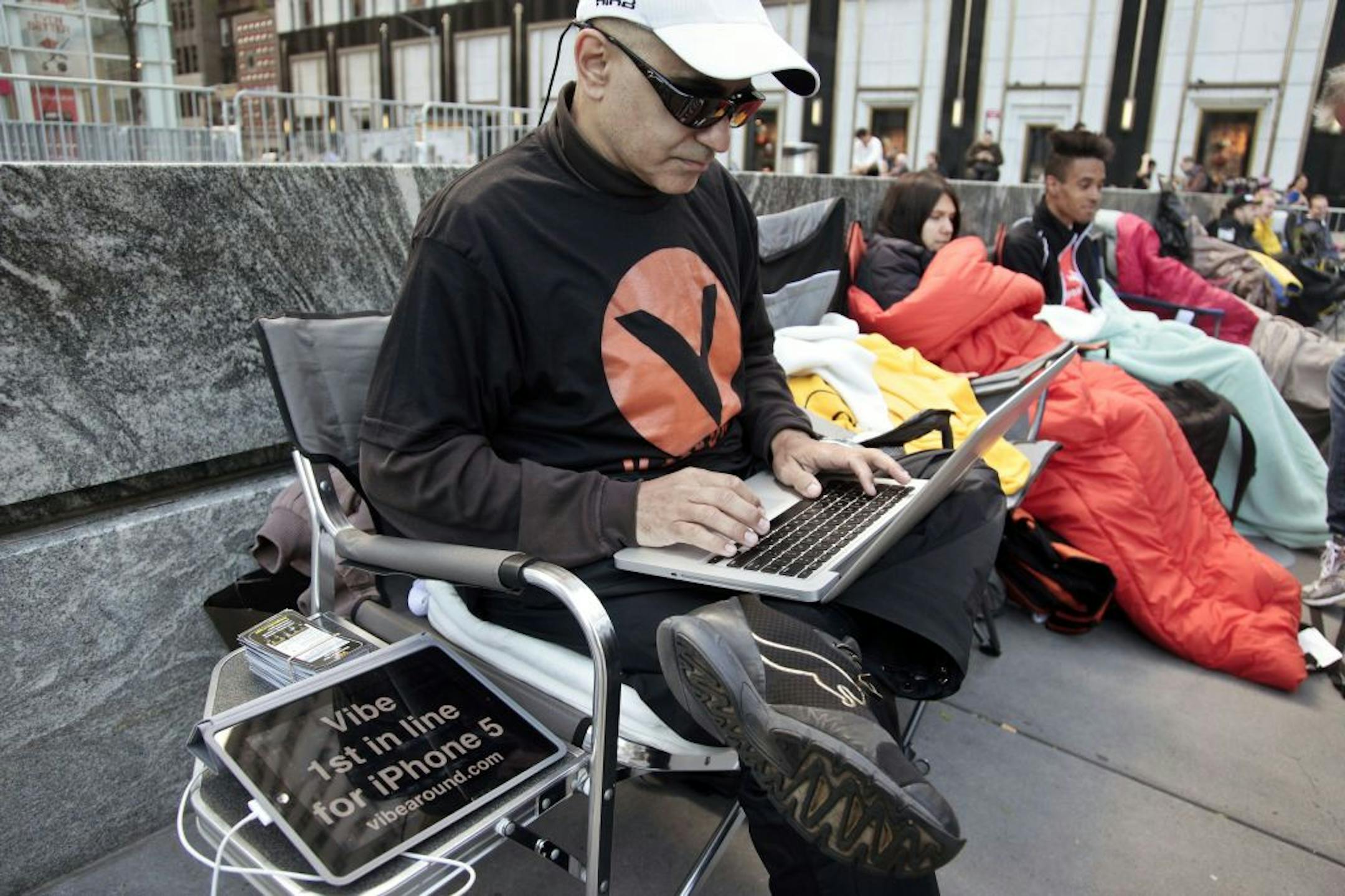 Hazen Sayer, an app developer, is first in line outside Apple's Fifth Avenue store on Thursday, Sept. 20, 2012, in New York. Sayer started camping out a week ago to be one of the first to get the new iPhone 5, which will go on sale in the U.S. and eight other countries next Friday, Sept. 21.