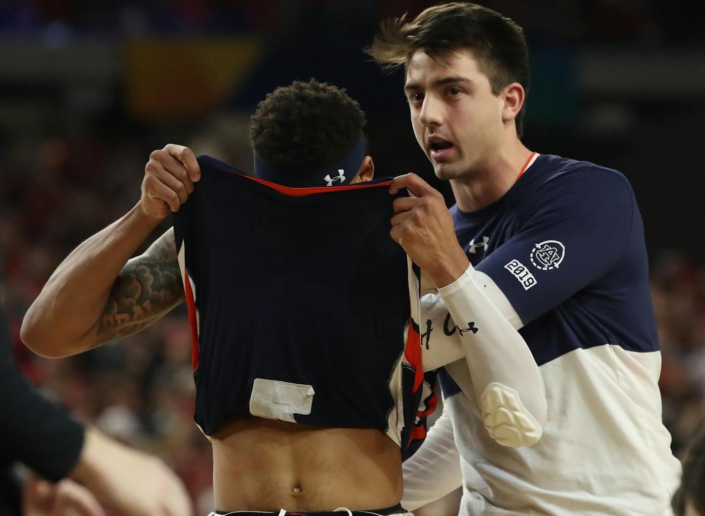 Auburn guard Bryce Brown is consoled by a teammate after losing to Virginia.