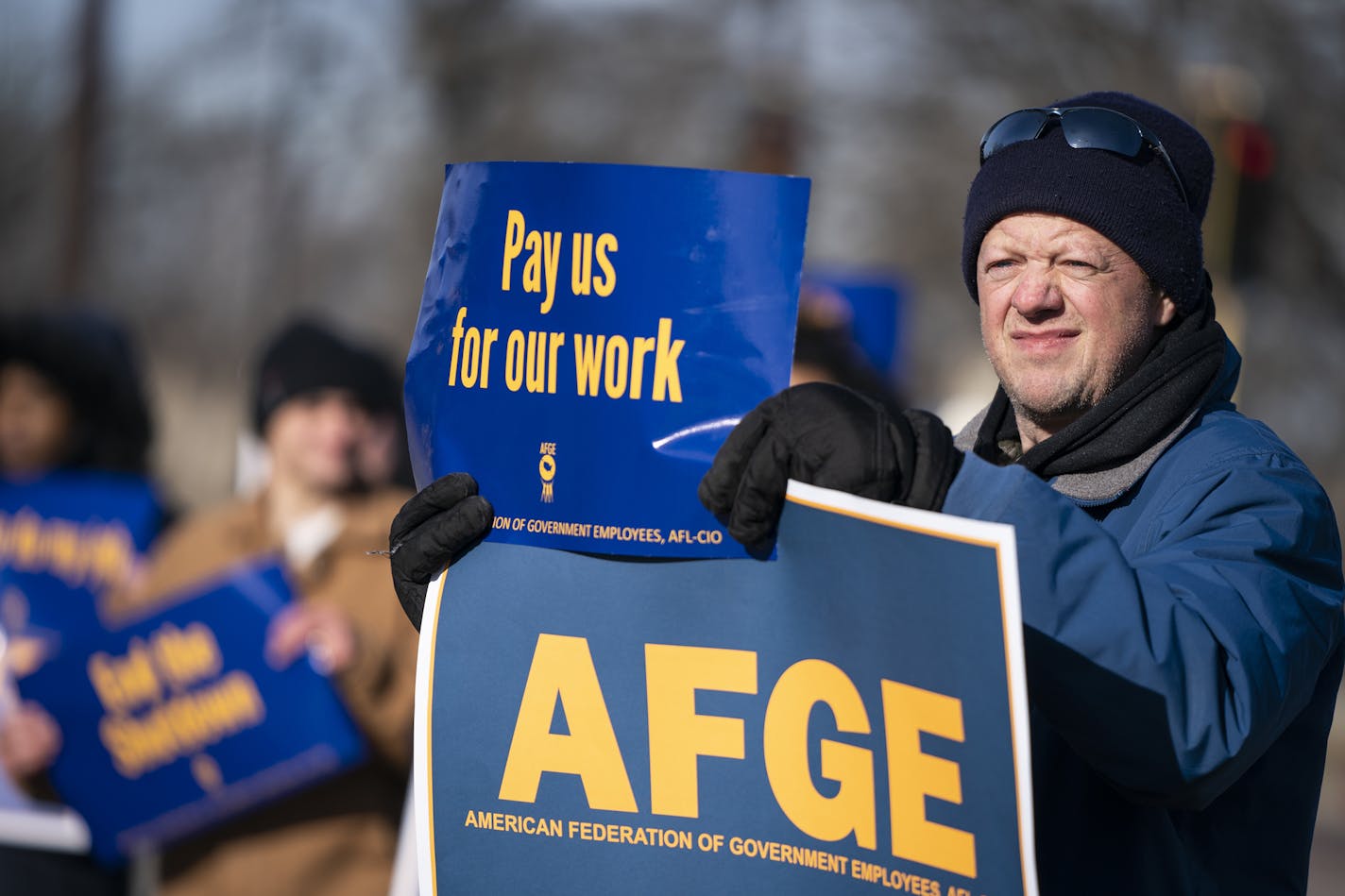 Brian Garthwaite, an FDA compliance officer who is currently furloughed and president of the American Federation of Government Employees Local 3381, holds up signs during the rally.. ] LEILA NAVIDI &#xa5; leila.navidi@startribune.com BACKGROUND INFORMATION: The American Federation of Government Employees holds a rally to highlight the effect the federal shutdown is having on its members at the corner of Hiawatha Avenue and 54th Street in Minneapolis on Thursday, January 10, 2019.