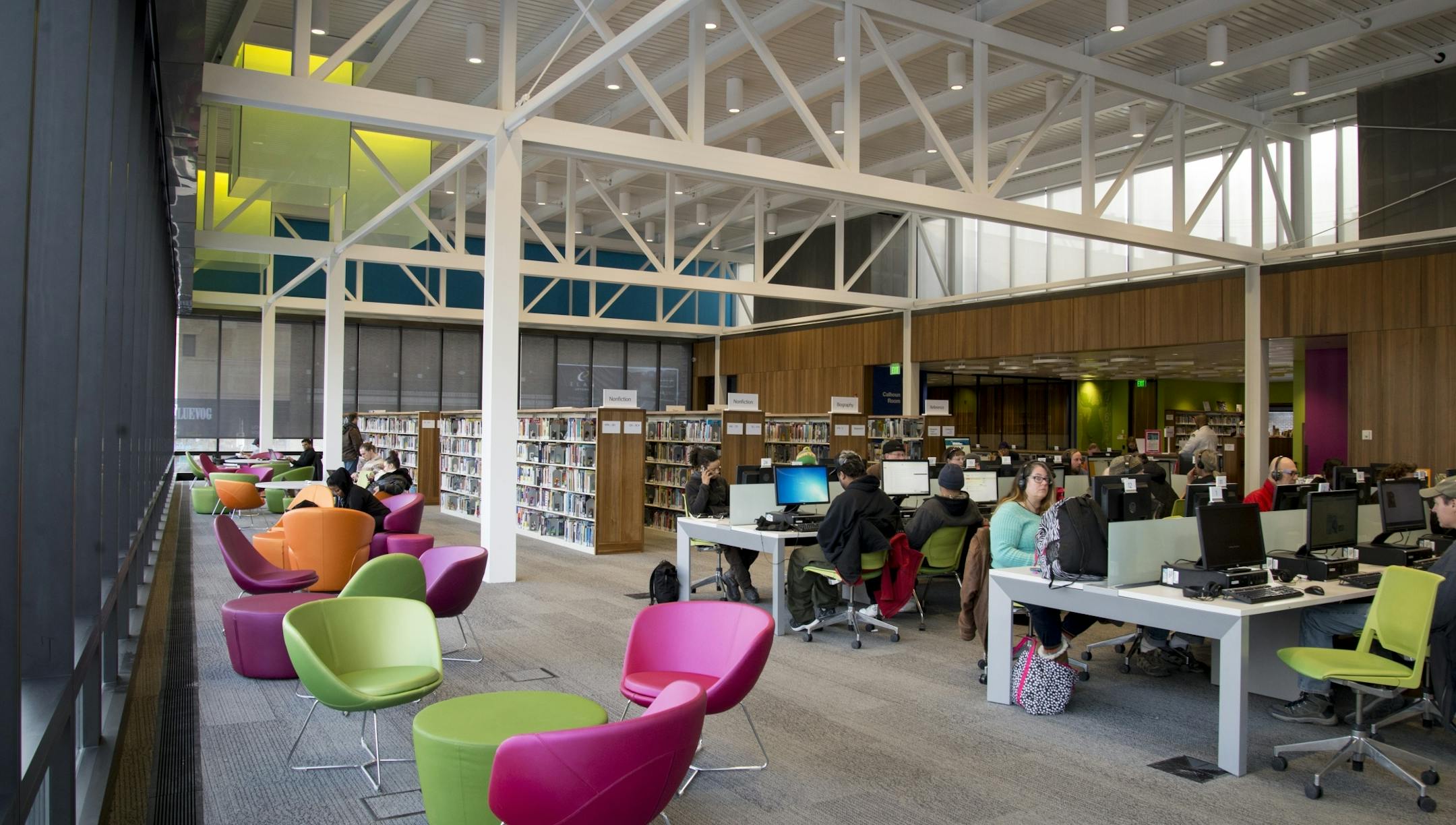 Visitors read in colorful chairs at Walker Library, designed by local firm Vince James and Associates.