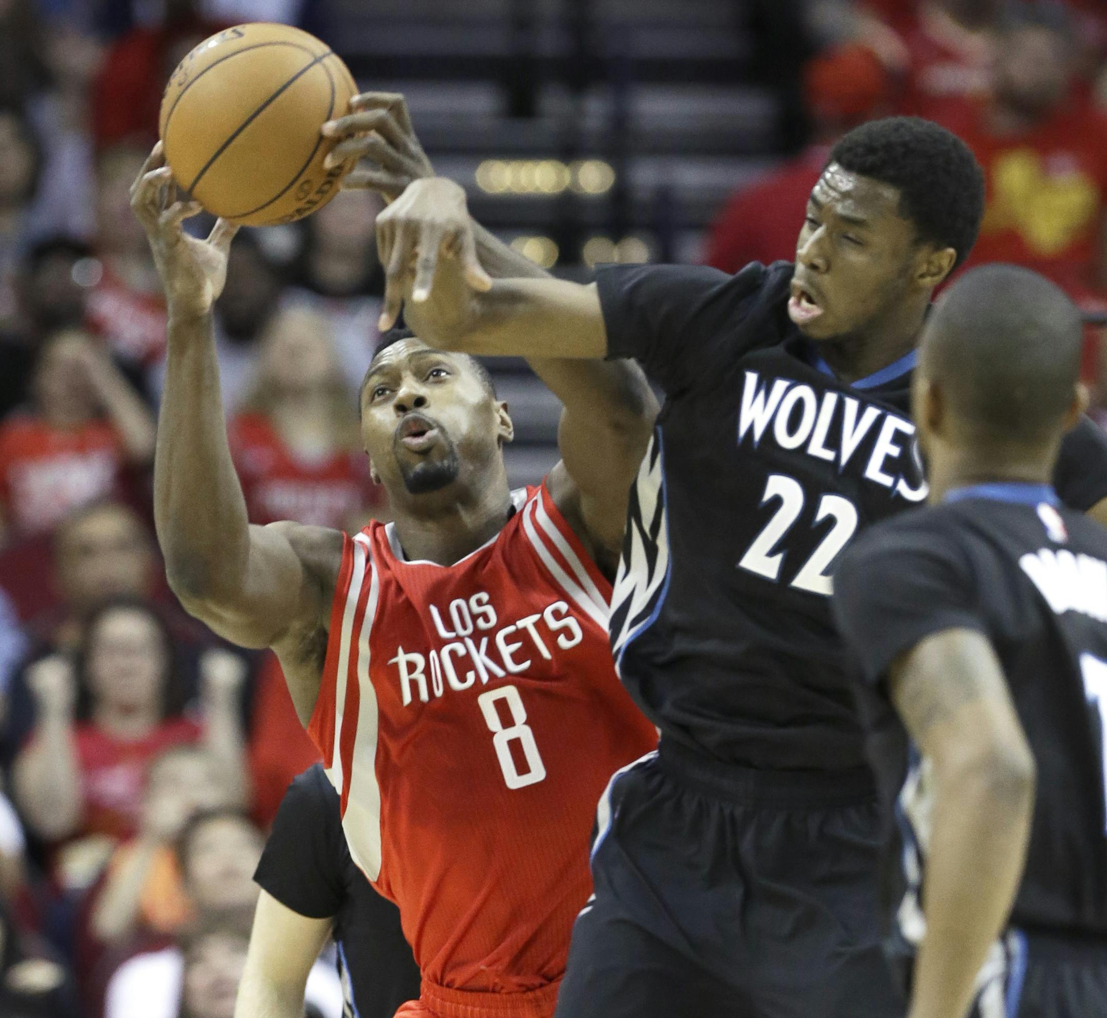 Houston Rockets' Joey Dorsey (8) grabs the ball next to Minnesota Timberwolves' Andrew Wiggins (22) in the first half of an NBA basketball game Friday, March 27, 2015, in Houston. (AP Photo/Pat Sullivan)