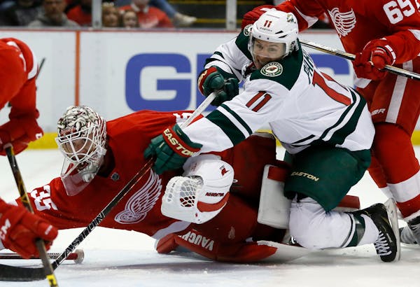 Minnesota Wild's Zach Parise (11) tries to take a shot on goal against Detroit Red Wings' Jimmy Howard (35) during the first period of an NHL hockey g