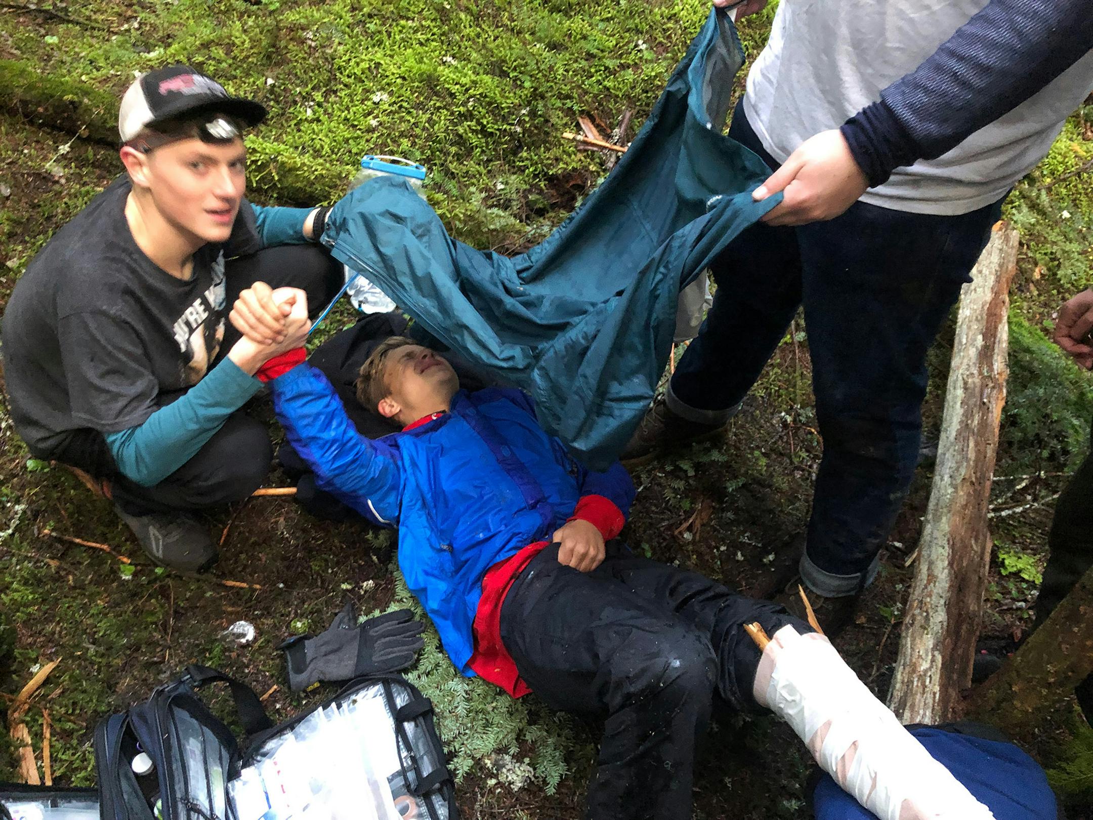 Addison Ditto is covered by his classmates who were trying to keep him warm after a falling tree broke his leg in North Idaho. (Courtesy photo/The Spokesman-Review/TNS) ORG XMIT: 1482592