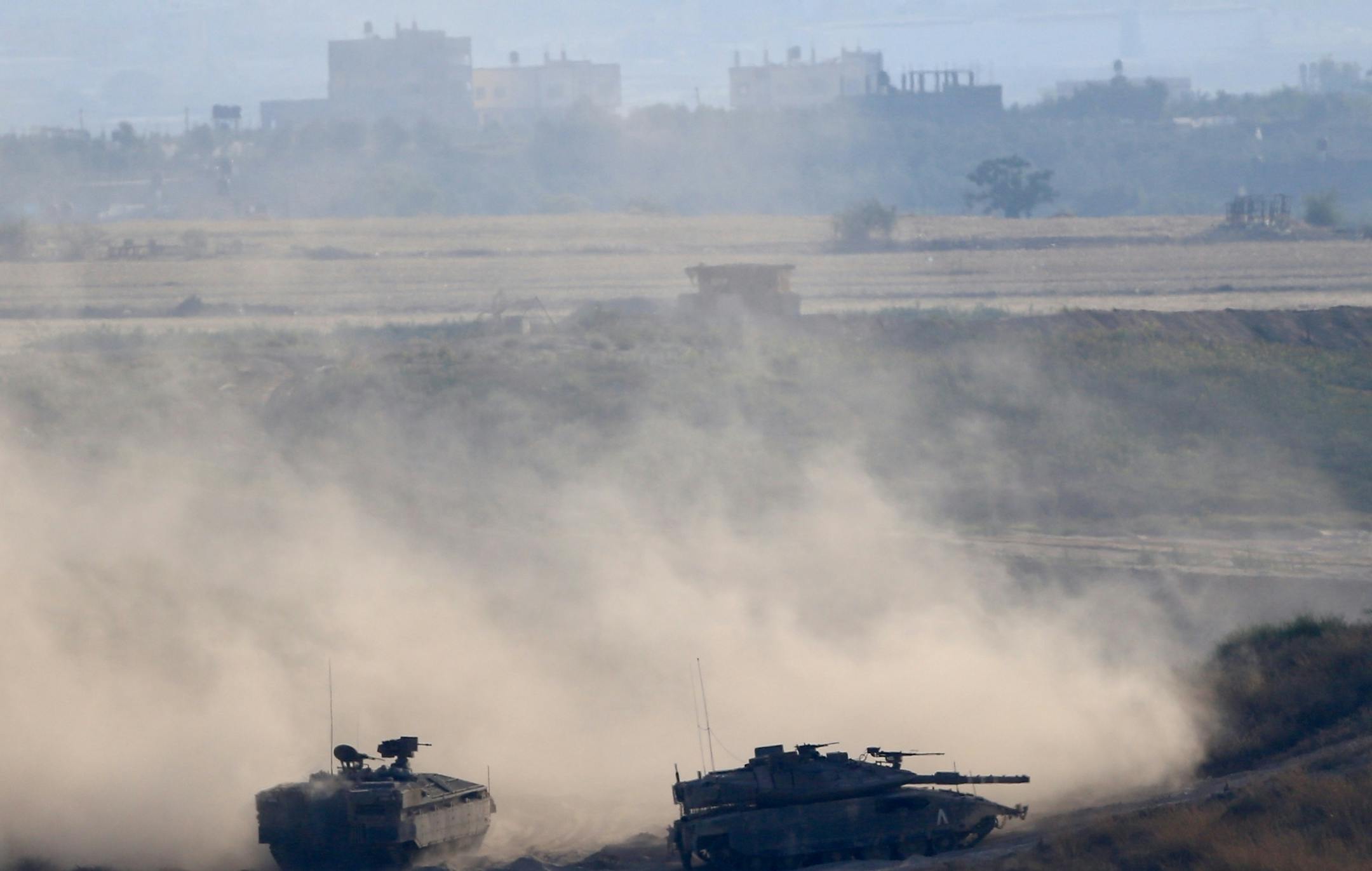 Israeli tanks take up positions along the border with the Gaza strip, on Israel-Gaza Border, Tuesday, May 29, 2018. The Israeli military said three soldiers were wounded by fire from the Gaza Strip on Tuesday. Tensions have soared over the past two months as the Palestinians have held mass protests along the Gaza-Israel frontier. Israeli fire has killed more than 100 Palestinians and wounded thousands at the protests since March. (AP Photo/Ariel Schalit)