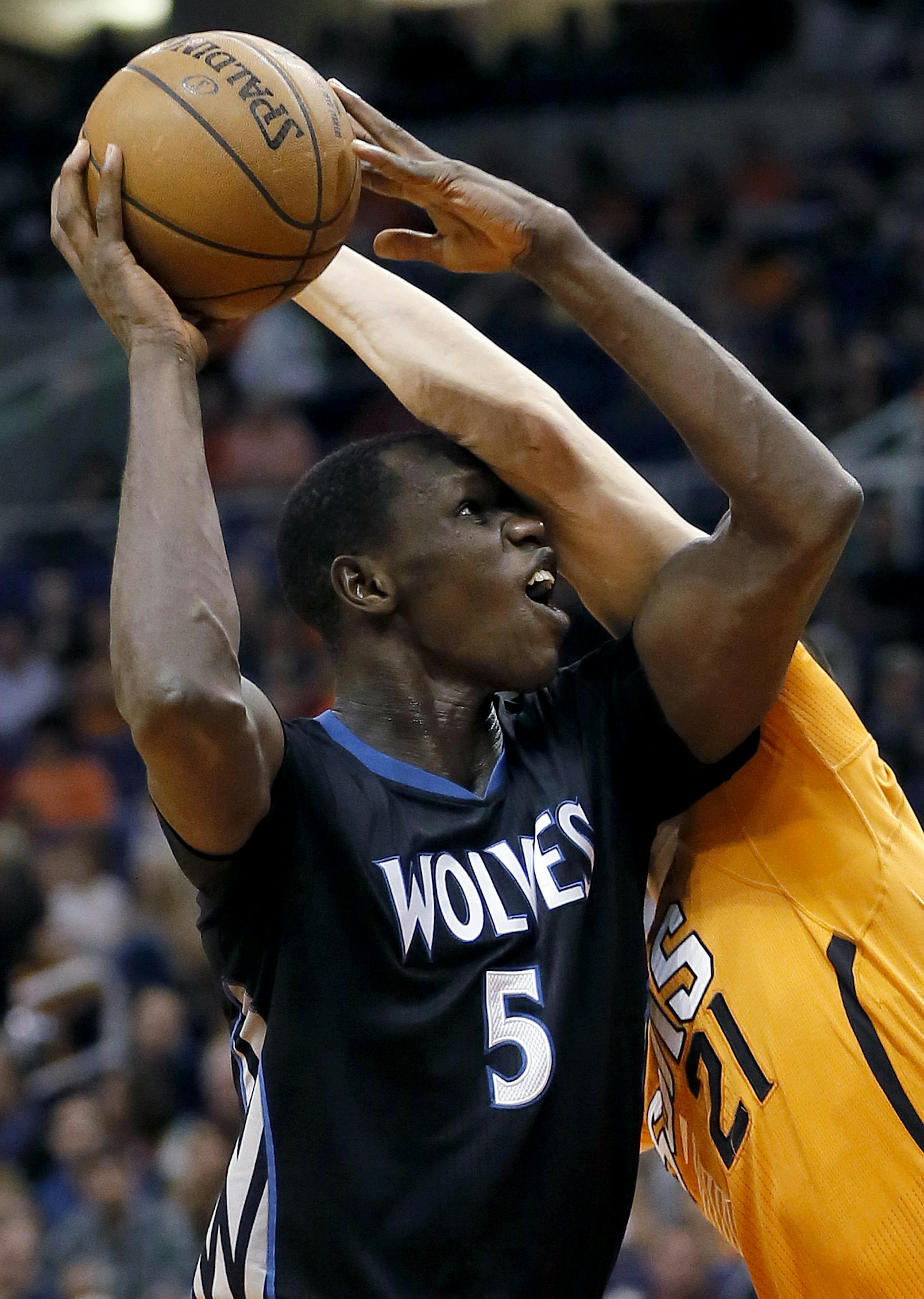 Minnesota Timberwolves' Gorgui Dieng (5), of Senegal, tries to shoot over Phoenix Suns' Alex Len during the first half of an NBA basketball game, Friday, Jan. 16, 2015, in Phoenix. (AP Photo/Matt York)