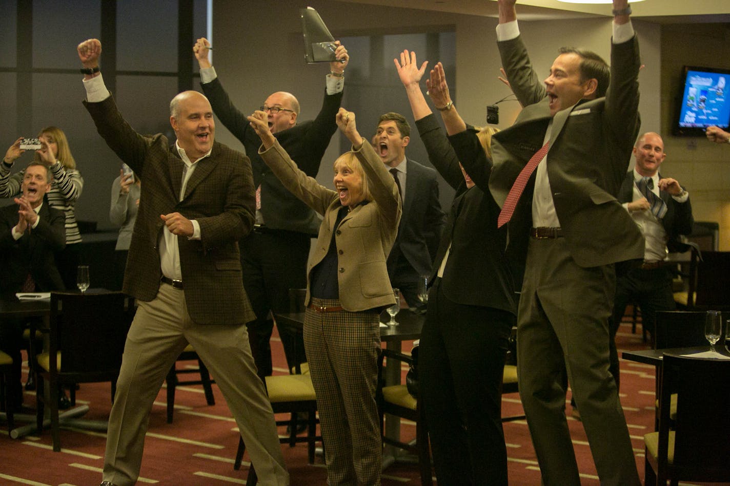 University of Minnesota officials, including Athletics Director Norwood Teague, left, co-chair of the Minneapolis bid committee David Mortenson, right, and Michele Kelm-Helgen, chair Minnesota Sport Facilities Authority, center. celebrate the 2019 Final Four bid.