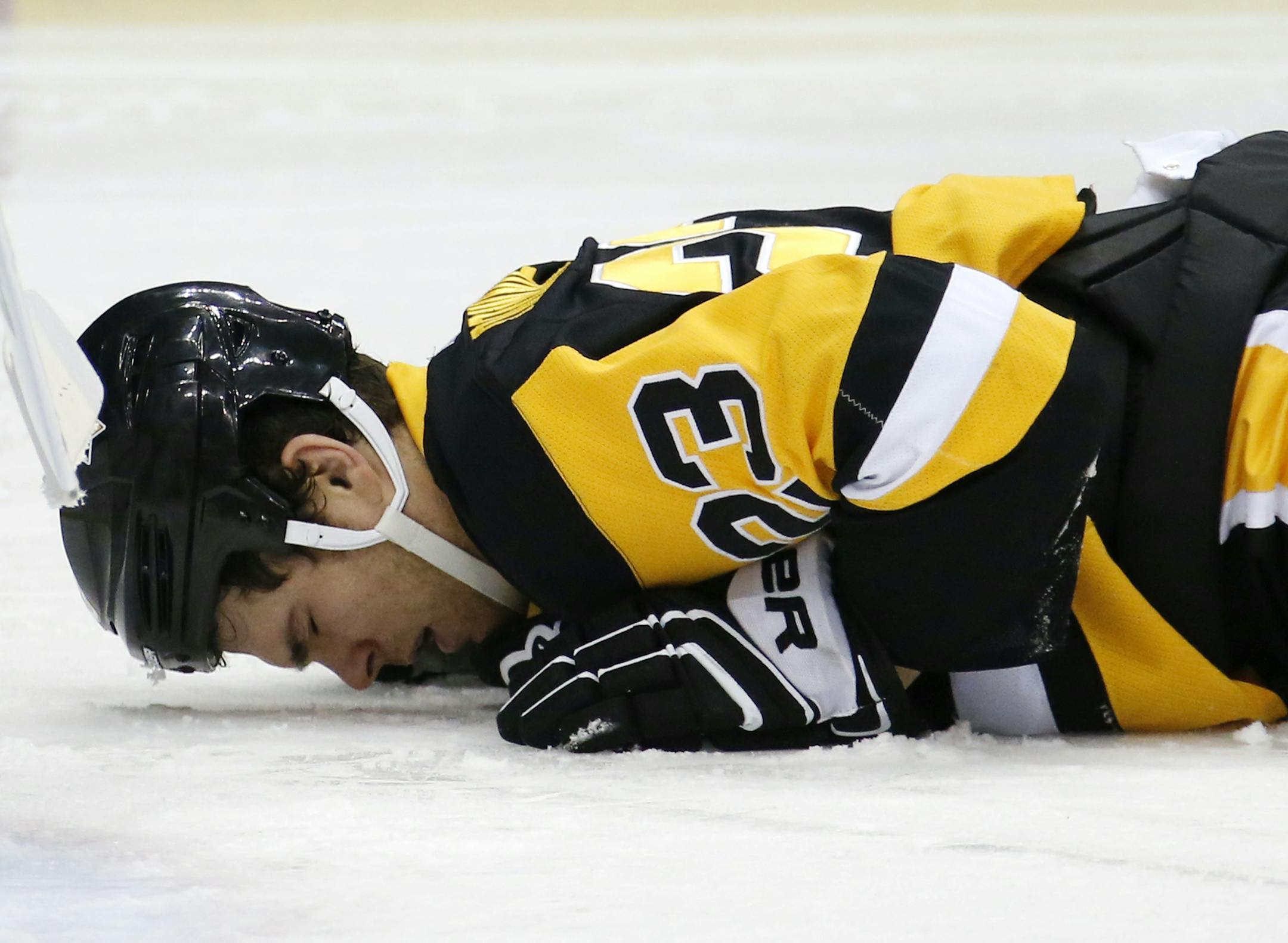 In this Jan. 13, 2015 file photo Pittsburgh Penguins' Steve Downie (23) lies on the ice after taking an elbow to the face from Minnesota Wild defenseman Ryan Suter during the second period of an NHL hockey game in Pittsburgh Tuesday, Jan. 13, 2015. Downie left the game and his condition has not been announced by the Penguins. (AP Photo/Gene J. Puskar)