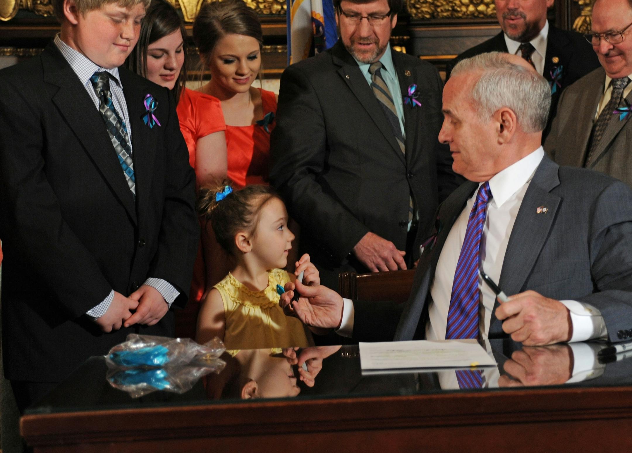 Jacob Gould on the left , now 12, and his family joined Gov Mark Dayton in the Governors Reception room at the State Capital on Wednesday April 4, 20112 as he signed the measure, known as "Jacob's Law." Jacob's 3 year old sister Isabelle Guggisberg, helped the Governor pass out the signing pens