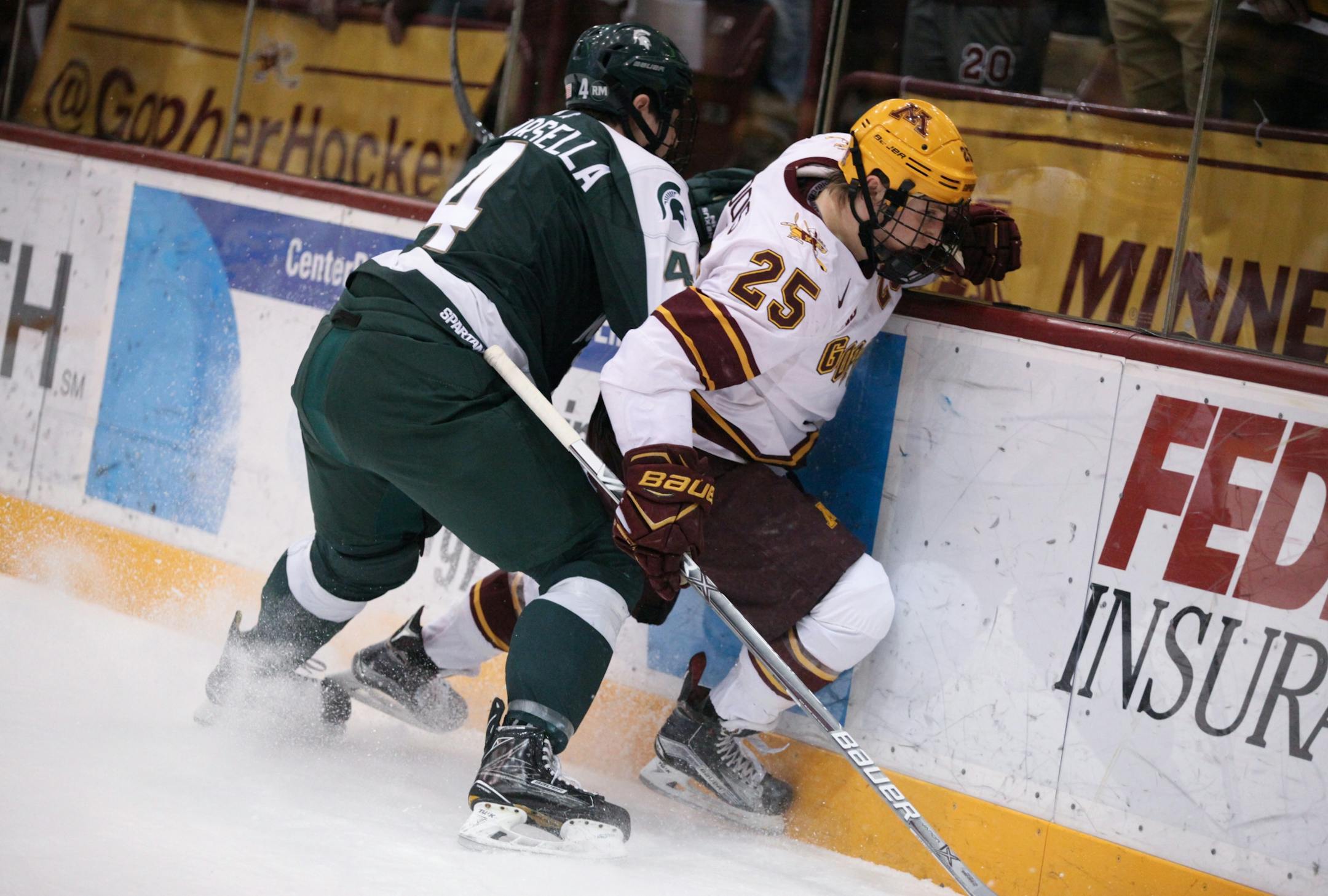 Michigan State Spartans� Anthony Scarsella (4) checks Minnesota Gophers� Justin Kloos (25) into the boards in the first period.