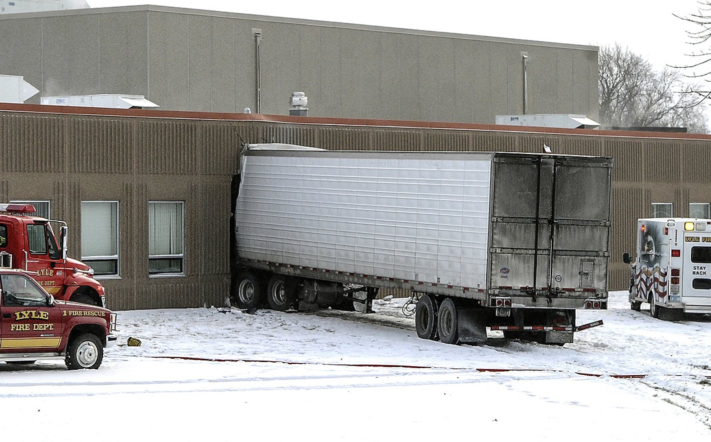 A semitrailer is embedded in the side of Lyle Public School Tuesday morning, Jan. 16, 2018 after it veered off a highway and crashed through the wall of the elementary school in Lyle, Minnesota. The semi left Highway 218 in Lyle after trying to avoid a car making a turn, striking it in the right rear of the vehicle. (Eric Johnson/The Daily Herald via AP)