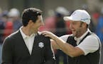 Europe's Andy Sullivan congratulates Europe's Rory McIlroy after McIlroy holed his approach shot on the sixth hole during a practice round for the Ryd