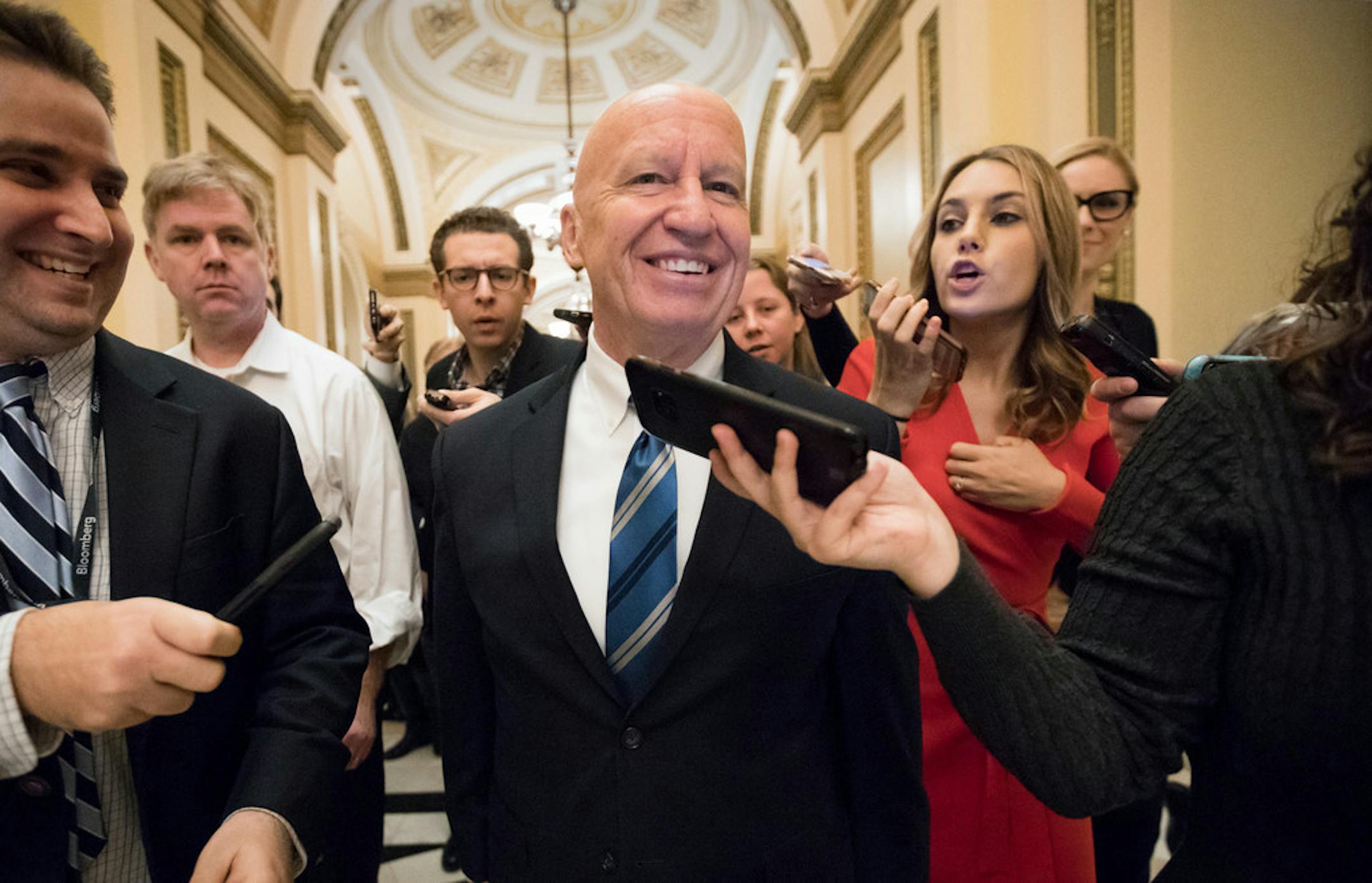 House Ways and Means Committee Chairman Kevin Brady, R-Texas, is pursued by reporters in the Capitol after signing the conference committee report to advance the GOP tax bill, in Washington, Friday