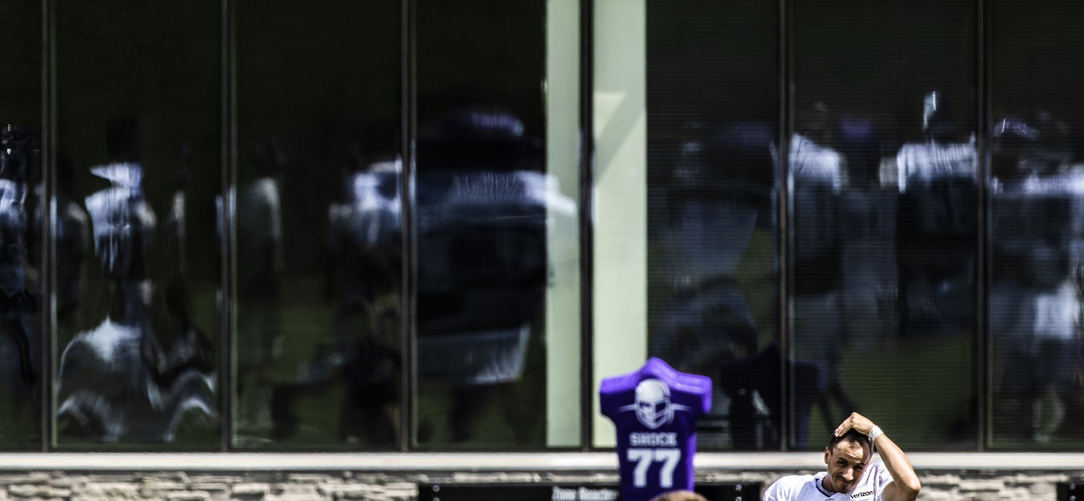 Reflections of Minnesota Vikings on the windows of TCO Performance Center during practice.