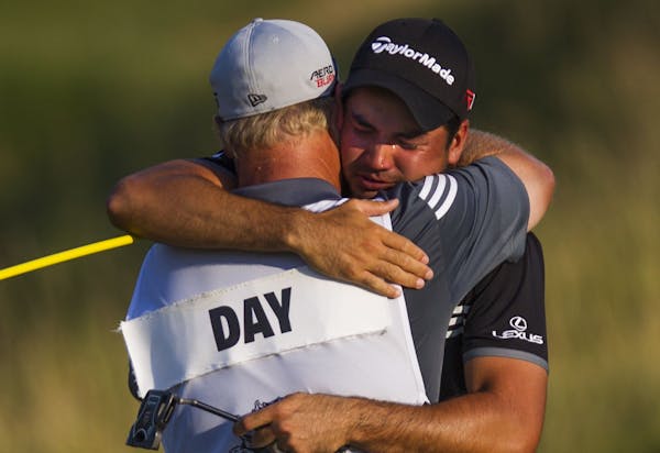 Jason Day hugs his caddie, Colin Swatton, after making par on the 18th hole and winning the 2015 PGA Championship on Sunday, Aug. 16, 2015, at Whistli