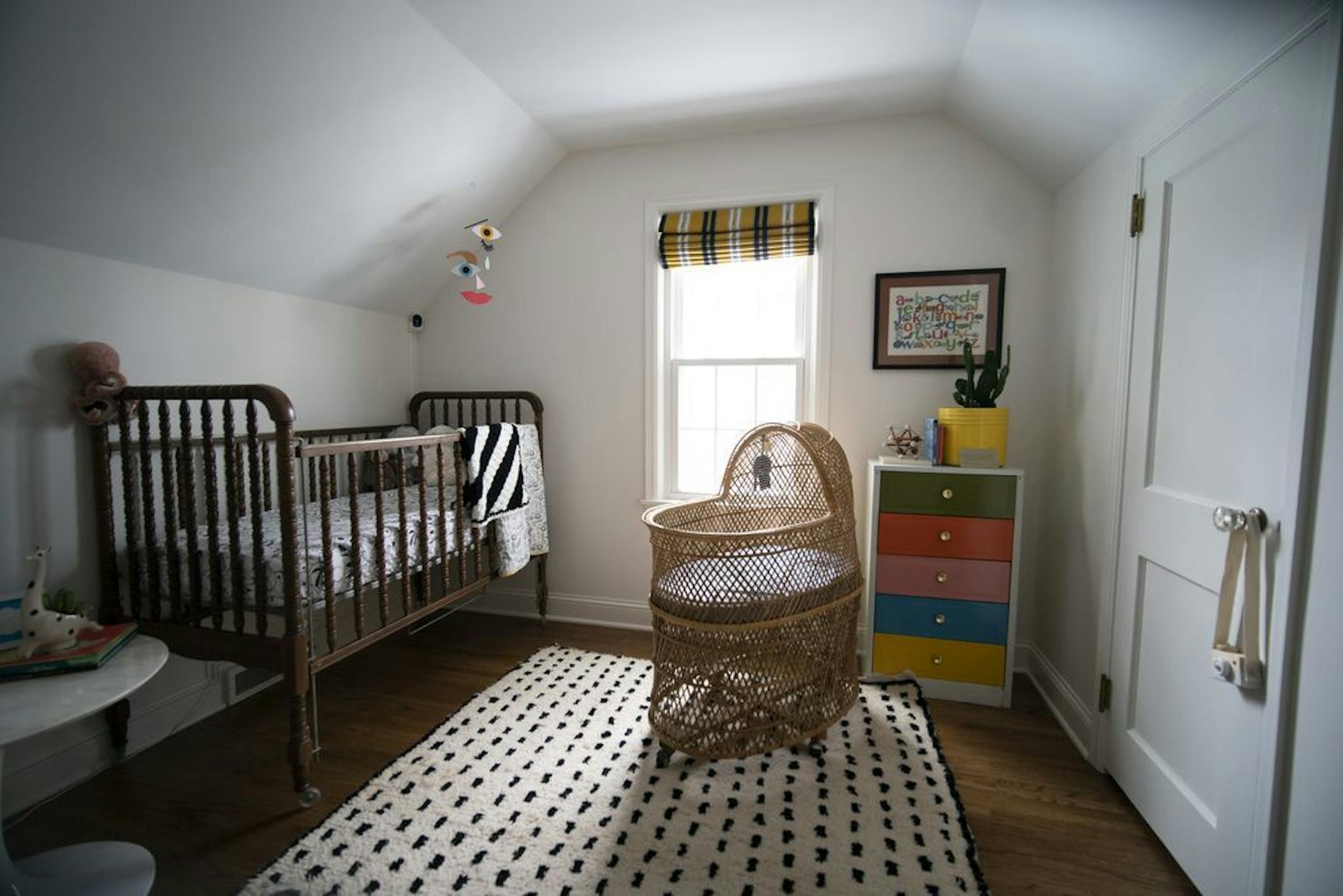 The nursery features a vintage crib, dresser and bassinet.