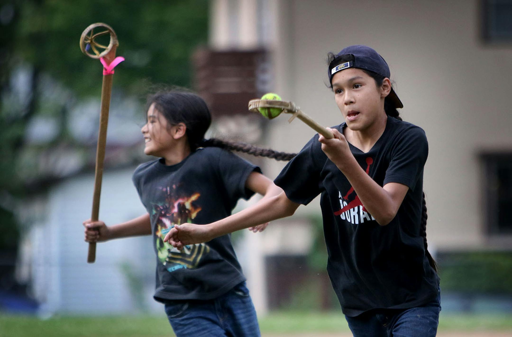 Youth members of Twin Cities Native Lacrosse and brothers Bronson Grant, right, and Quinlan Grant practice at Corcoran Park Wednesday, June 17, 2015, in Minneapolis, MN. The traditional Lacrosse players, who play with hand carved ash sticks, were preparing for the upcoming Twin Cities Native Lacrosse Tournament at the Osseo High School Saturday.