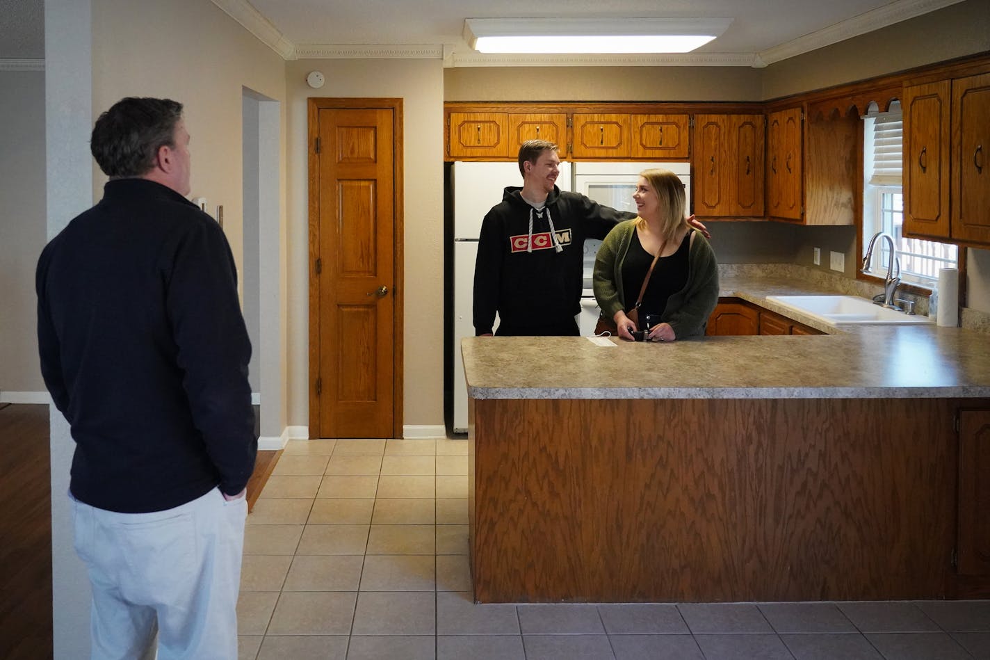 Elizabeth Mayer and Damon Madzey bought this twinhome in Mounds View. They bid more than the list price to ensure the seller would take their offer. At left is the listing agent, Realtor Chris Willette.