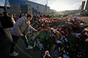 People place flowers at a makeshift memorial in front of the Crocus City Hall on the western outskirts of Moscow on Monday in the wake of terror attac