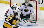 Minnesota Wild goalie Devan Dubnyk (40) stops a shot by Pittsburgh Penguins' Sidney Crosby (87) with Ryan Suter (20) defending during the first period