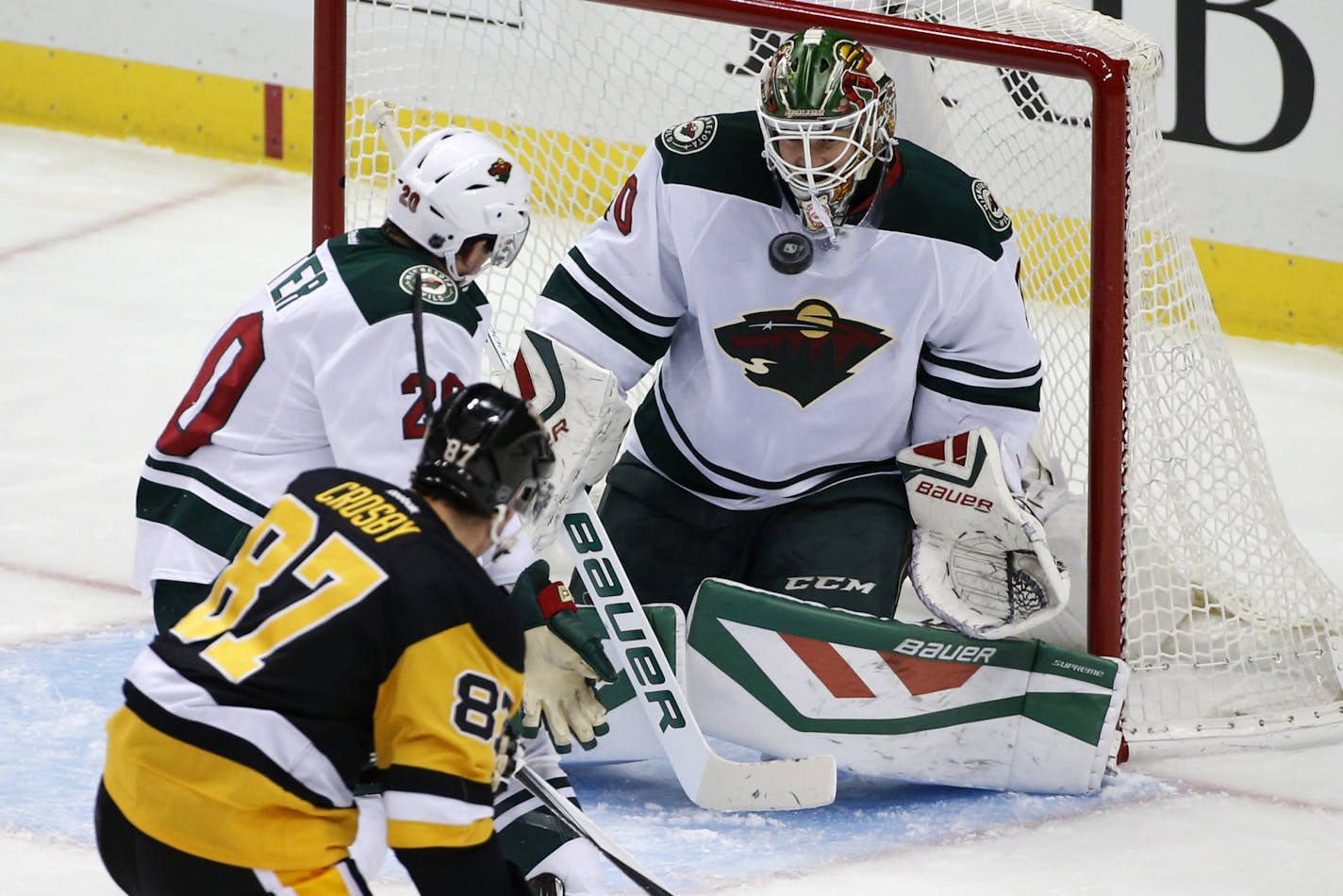 Minnesota Wild goalie Devan Dubnyk (40) stops a shot by Pittsburgh Penguins' Sidney Crosby (87) with Ryan Suter (20) defending during the first period of an NHL hockey game in Pittsburgh Tuesday, Nov. 17, 2015.