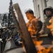 Members of a civilian defense unit stand guard near a fire after marching to the Verkhovna Rada parliament building in Kiev, Ukraine, Feb. 25, 2014. S