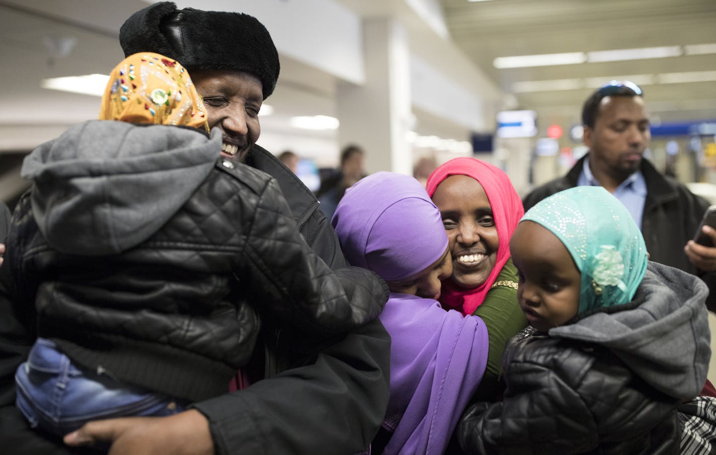 Mohamed lye held his 4-year-old daughter Nimo, as he was reunited with his wife Saido Ahmed Abdille (wearing red scarf) and their other daughter Nafiso, 2, at right at MSP Airport after arriving from Amsterdam Sunday Feb 5, 2017 in Bloomington, MN. JERRY HOLT &#xef; jerry.holt@startribune.com