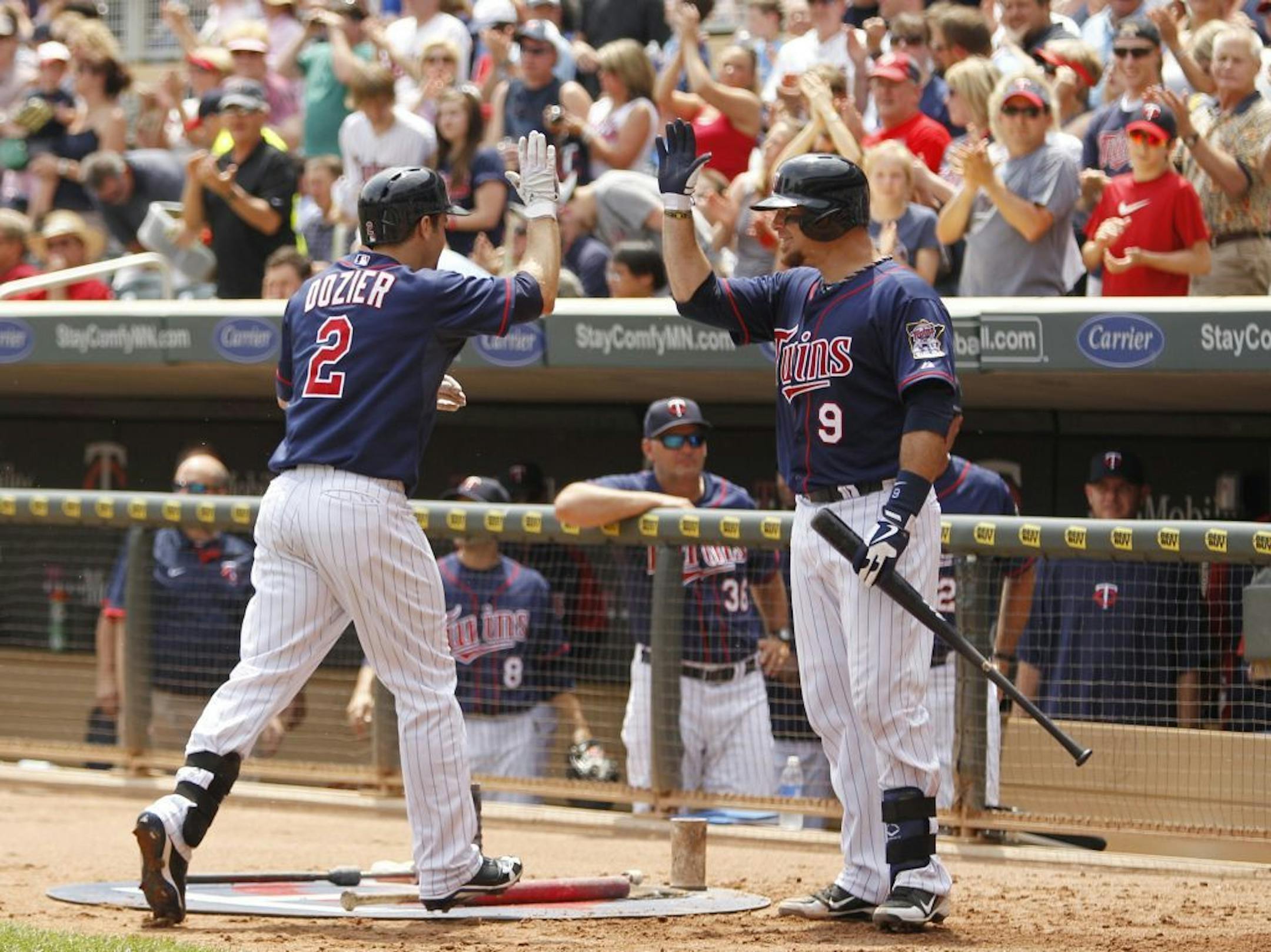 Minnesota Twins' Brian Dozier (2) is congratulated by Ryan Doumit (9) after hitting a two-run home run against Chicago White Sox starting pitcher John Danks during the second inning of a baseball game, Thursday, June 20, 2013, in Minneapolis.