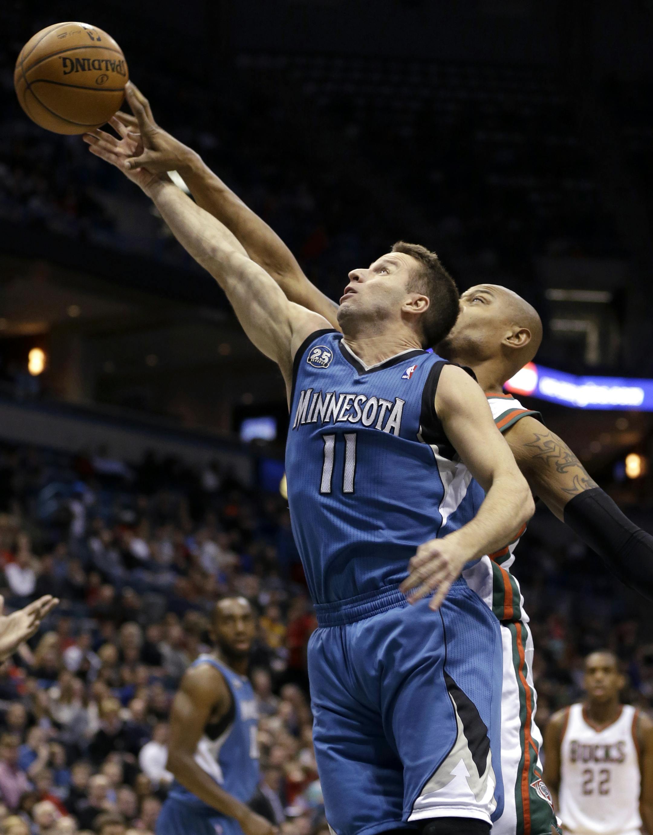 Milwaukee Bucks' Caron Butler blocks the shot of Minnesota Timberwolves' Jose Barea (11) during the first half of an NBA basketball game, Saturday, Dec. 28, 2013, in Milwaukee. (AP Photo/Jeffrey Phelps) ORG XMIT: MIN2013122821361330