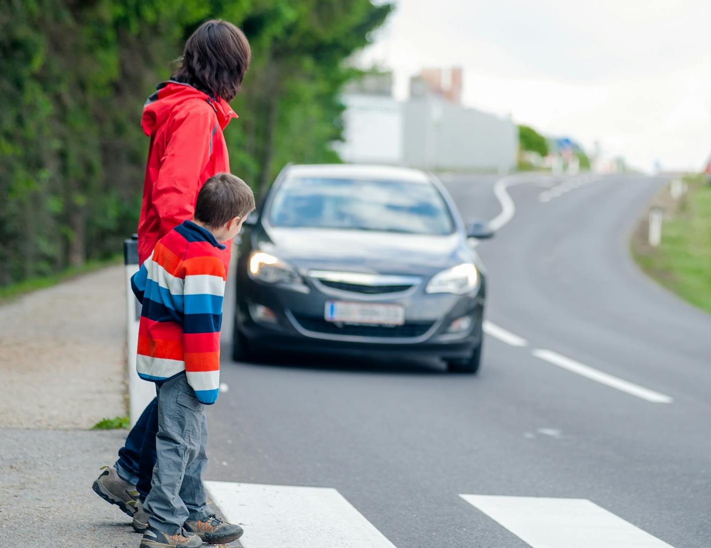 Mother and son passing a street when a car coming