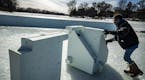 Alice Ferguson who works for Minneapolis Parks and Recreation put away the hockey rink pieces for the skating rink on Lake of the Isles in Minneapolis