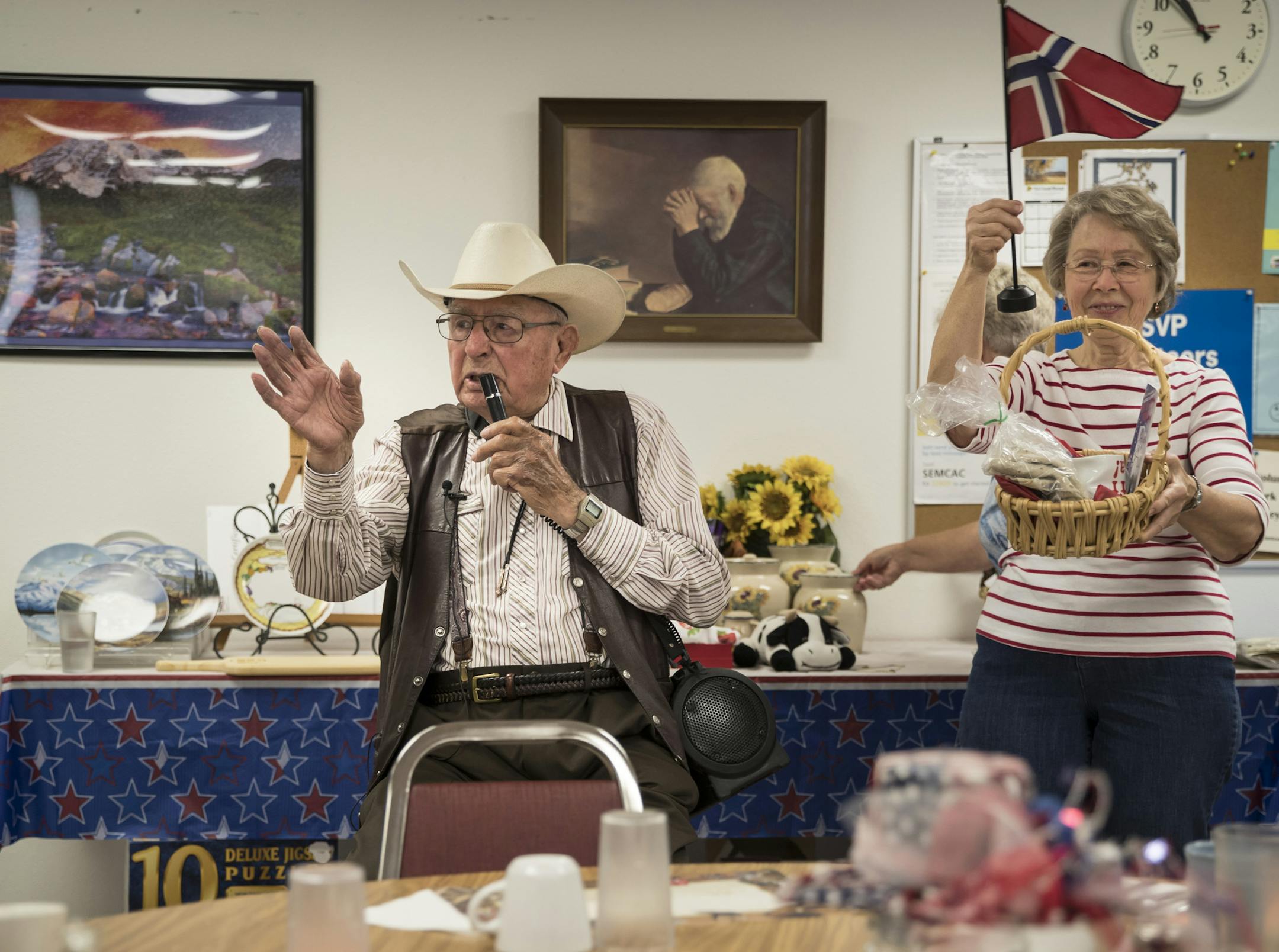 98-year-old Bert Boyum led a charity auction at the Tenborg community center in Rushford, Minn., on July 11, 2017. At right, his assistant (I don't have her id) held up a basket of Norwegian items he was auctioning off. ] RENEE JONES SCHNEIDER • renee.jones@startribune.com