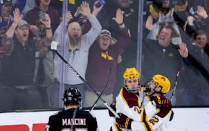 Jaxon Nelson (24) and Bryce Brodzinski (22) of the Minnesota Gophers celebrate a goal by Nelson in the third period Thursday.
