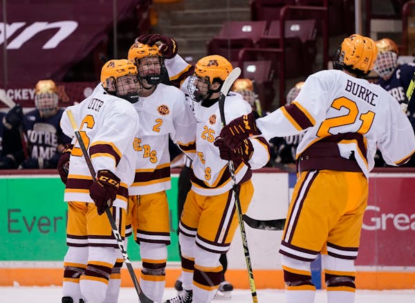 Gophers  defenseman Jackson LaCombe (2) celebrated with teammates after scoring a goal during the first period Friday.