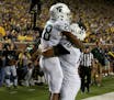 Michigan State running back Madre London (28) celebrates with teammate Tyler Higby (70) in the end zone after scored on a 16-yard pass reception again