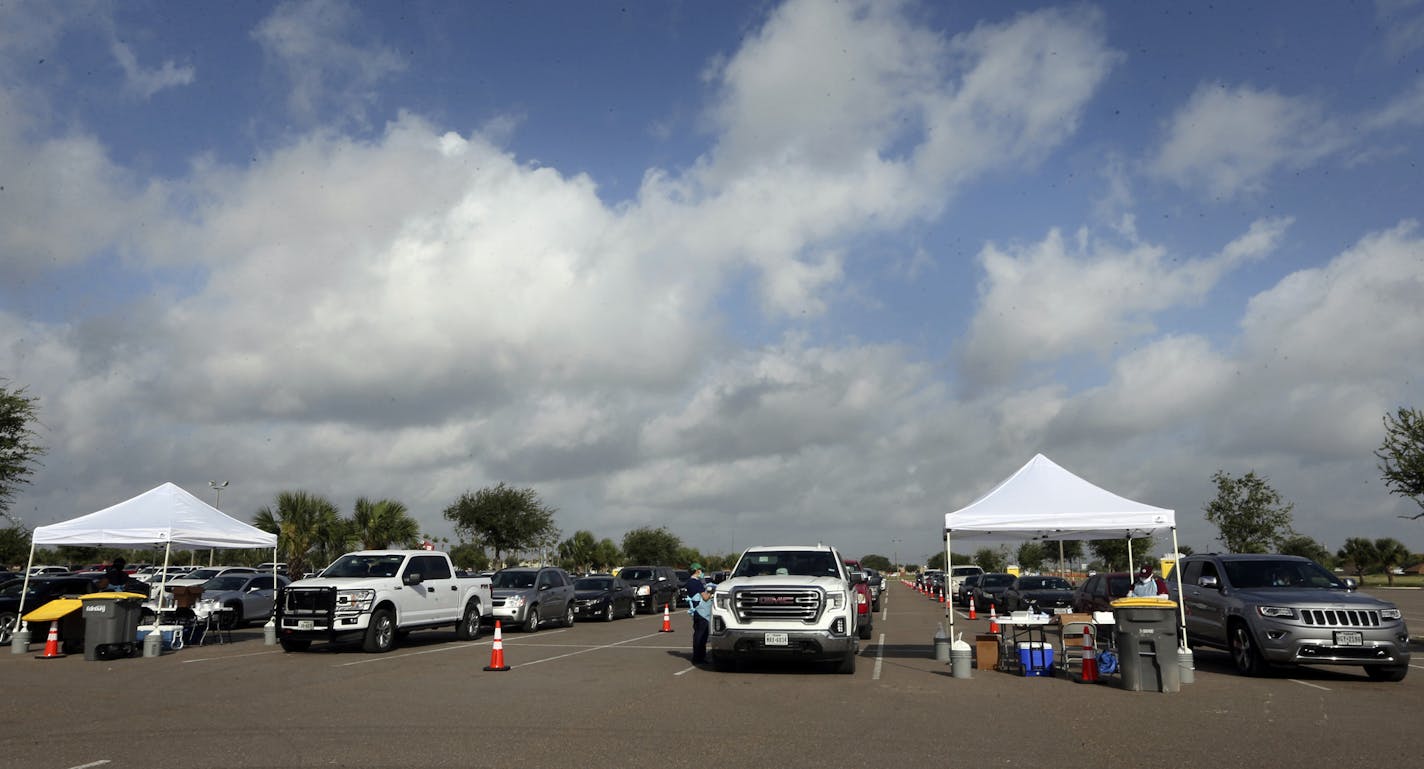 Health officials and members of the military assist during COVID-19 testing, Wednesday, July 8, 2020, at HEB Park in Edinburg, Texas. (Delcia Lopez/The Monitor via AP)