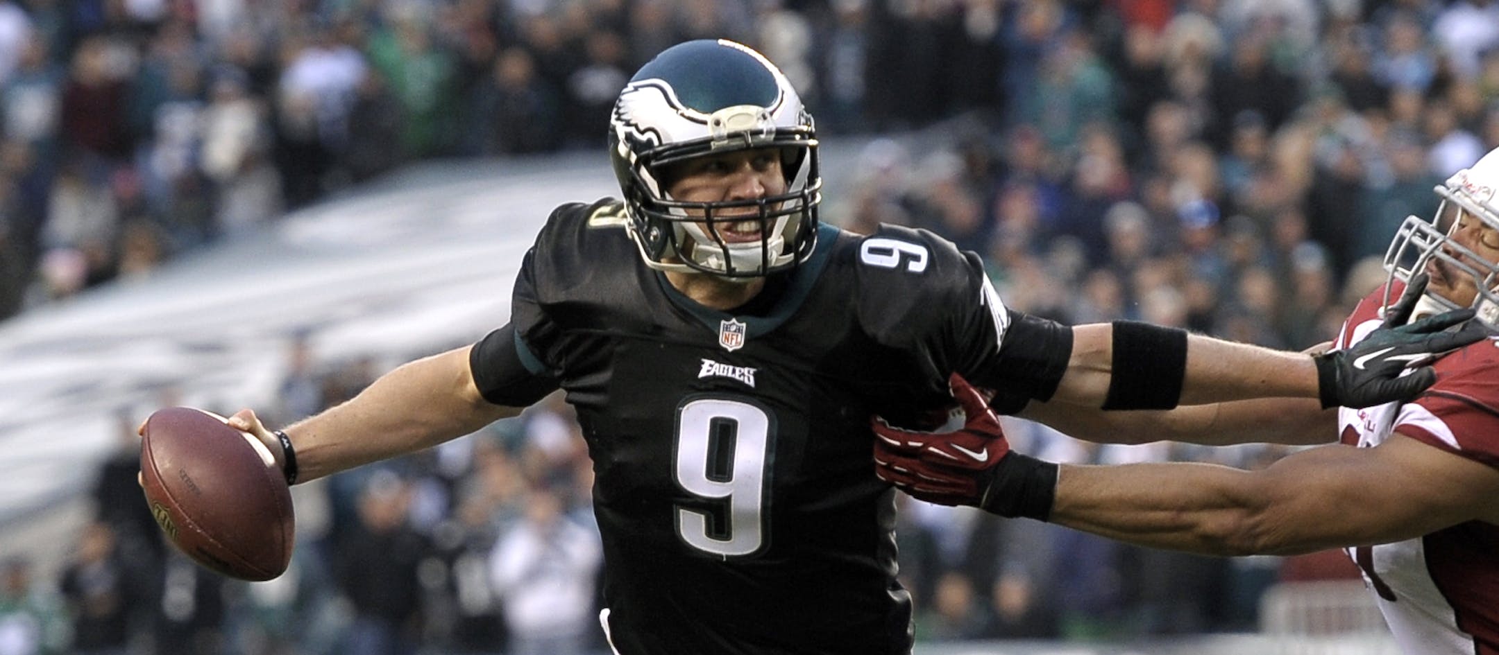 Philadelphia Eagles' Nick Foles, tries to break free of Arizona Cardinals' Matt Shaughnessy during the second half of an NFL football game, Sunday, Dec. 1, 2013, in Philadelphia. Philadelphia won 24-21. (AP Photo/Michael Perez)