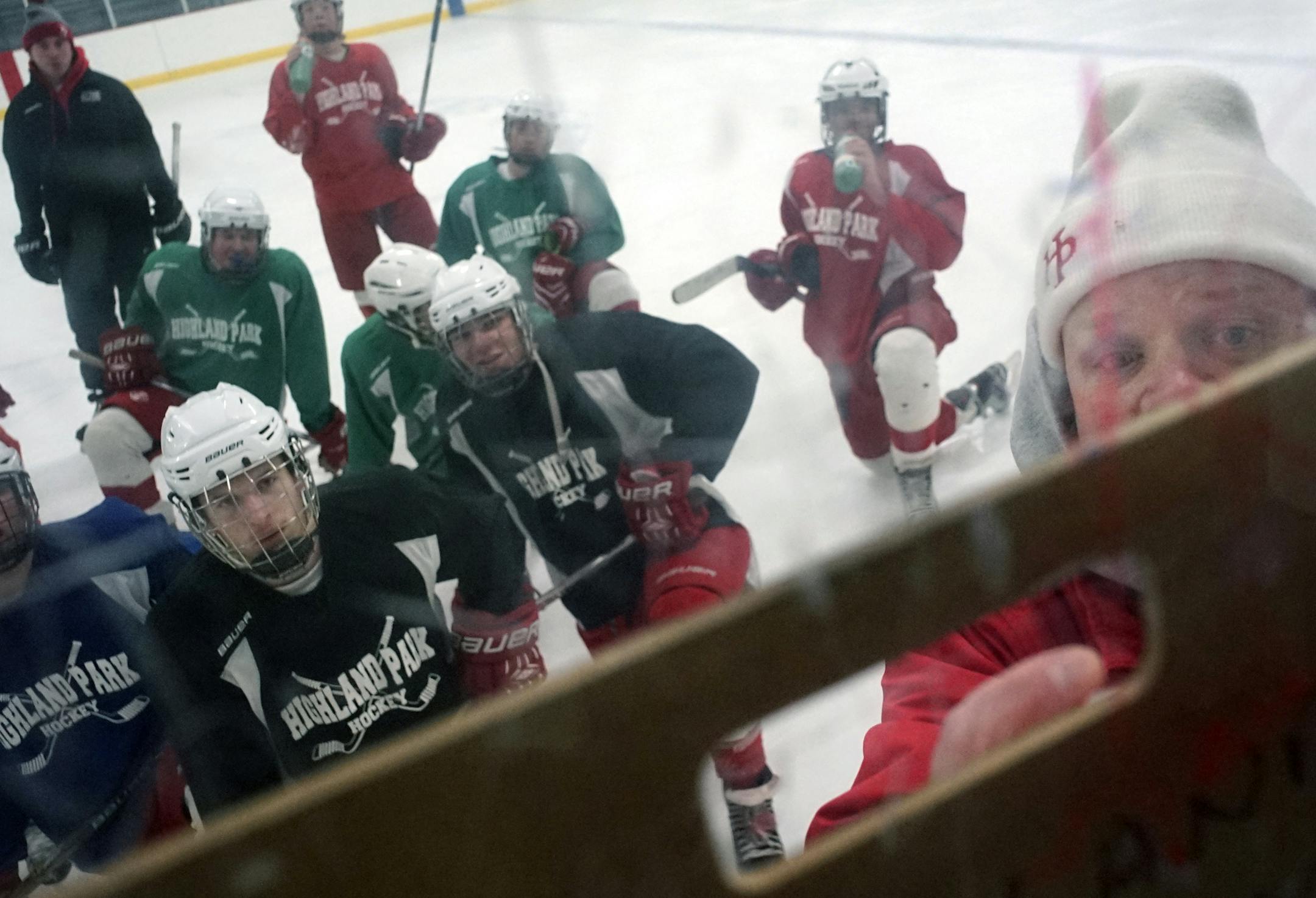 Players huddled behind coach and Highland Park graduate Pat Auran, right, as he drew up plays during practice. “We want to put a team on the ice every day that’s competitive,” Auran said.