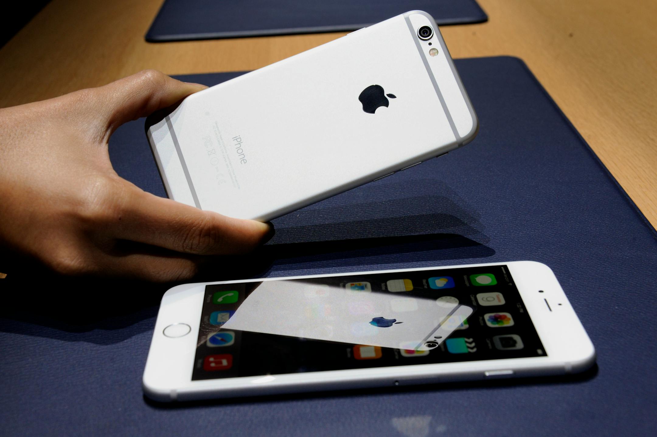 An attendee displays the new Apple Inc. iPhone 6 for a photograph as the iPhone 6 Plus is displayed after a product announcement at Flint Center in Cupertino, California, U.S., on Tuesday, Sept. 9, 2014. Apple Inc. unveiled redesigned iPhones with bigger screens, overhauling its top-selling product in an event that gives the clearest sign yet of the company's product direction under Chief Executive Officer Tim Cook. Photographer: David Paul Morris/Bloomberg