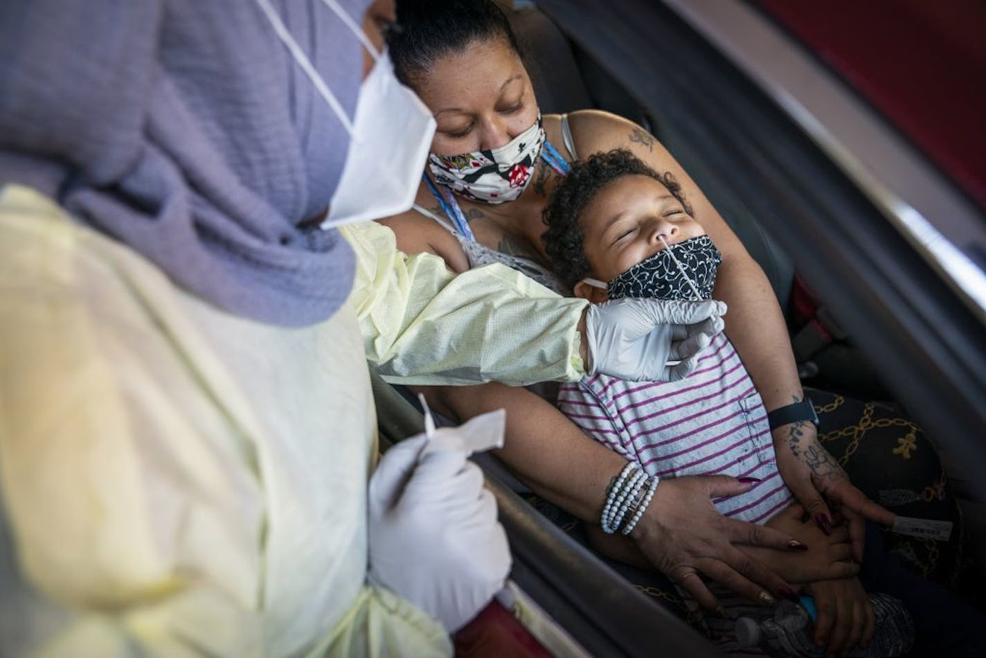 Jessica Steele of St. Paul held her son Little Bear Chatman, Jr., 6, as he was tested at the drive-through COVID-19 testing site at North Memorial Health in Robbinsdale.