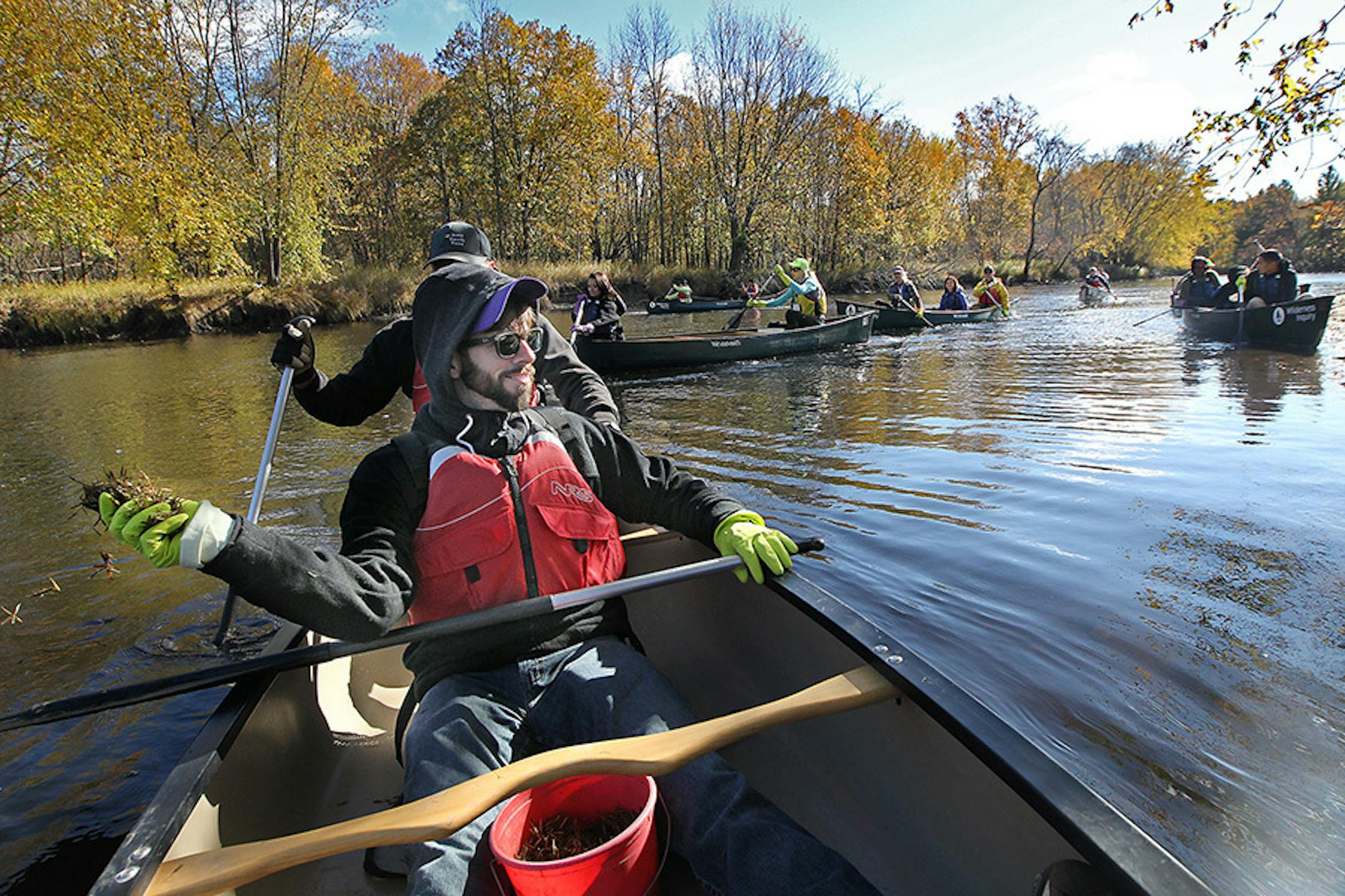 Takoda Prep teacher Thomas Lonetti threw wild rice seeds along the Rum River for planting, Tuesday, October 13, 2015 near Cambridge, MN.