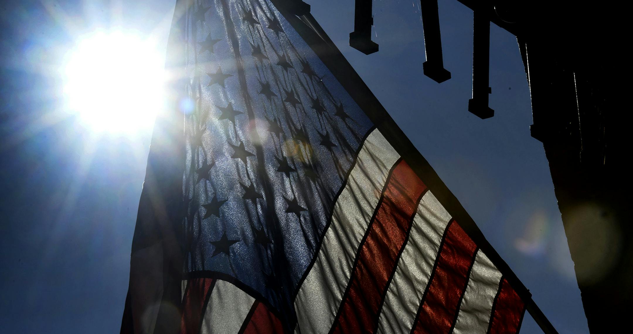 The sun rises behind an American flag posted outside of Petrunik's Kitchen, Door and Moore store at the old Eureka Department store in Windber, Pa., Wednesday, July 10, 2019. (Todd Berkey/The Tribune-Democrat via AP)