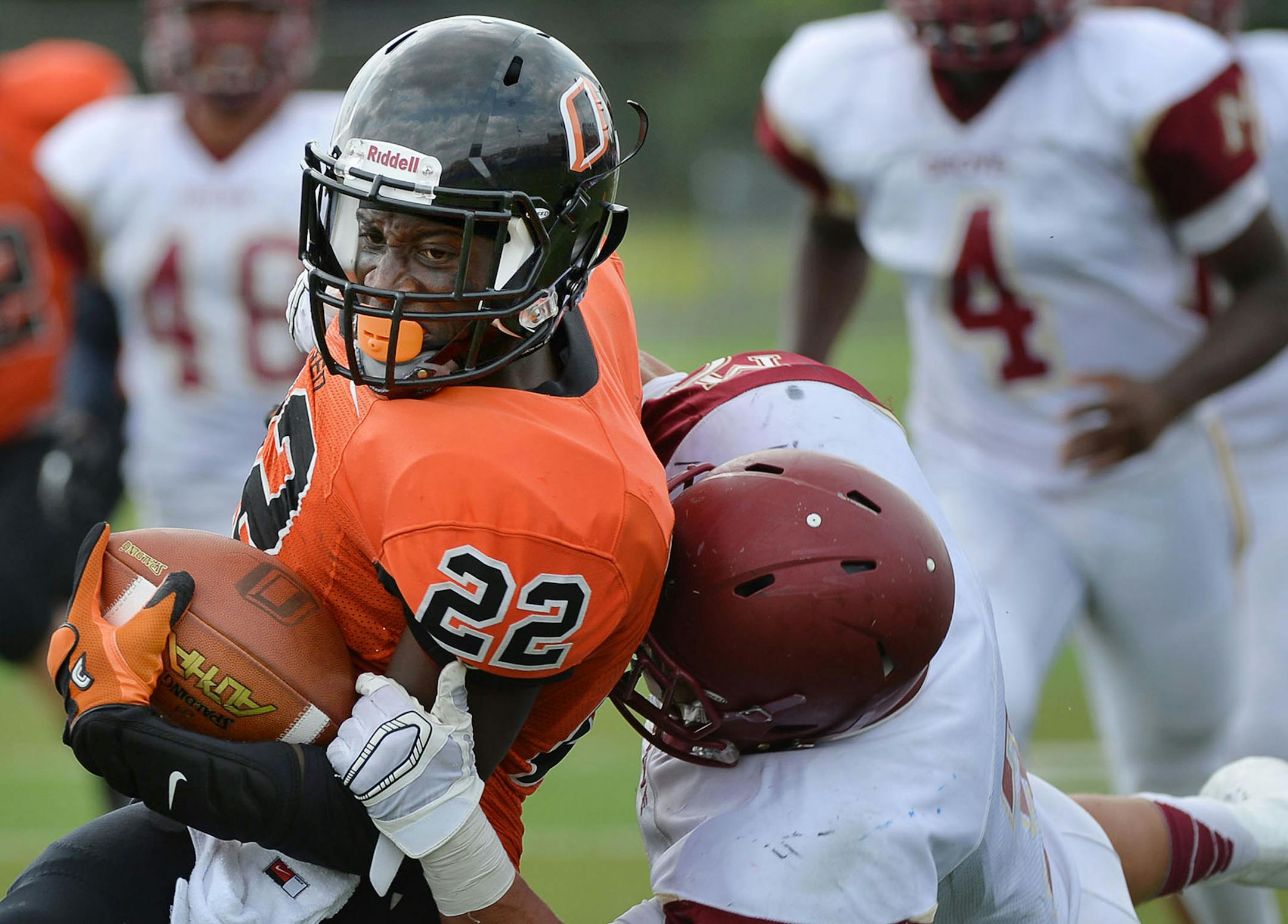 Osseo's Prince Kruah was tackled by Maple Grove defensive back Isaac Collins in an early-season game. Coaches of both those teams welcome seeding in Class 6A.