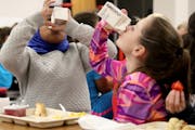Sioux Trail Elementary third-graders, Salma Omar, left, and Marriana Ristamaki-McKee tried to drink their milk.