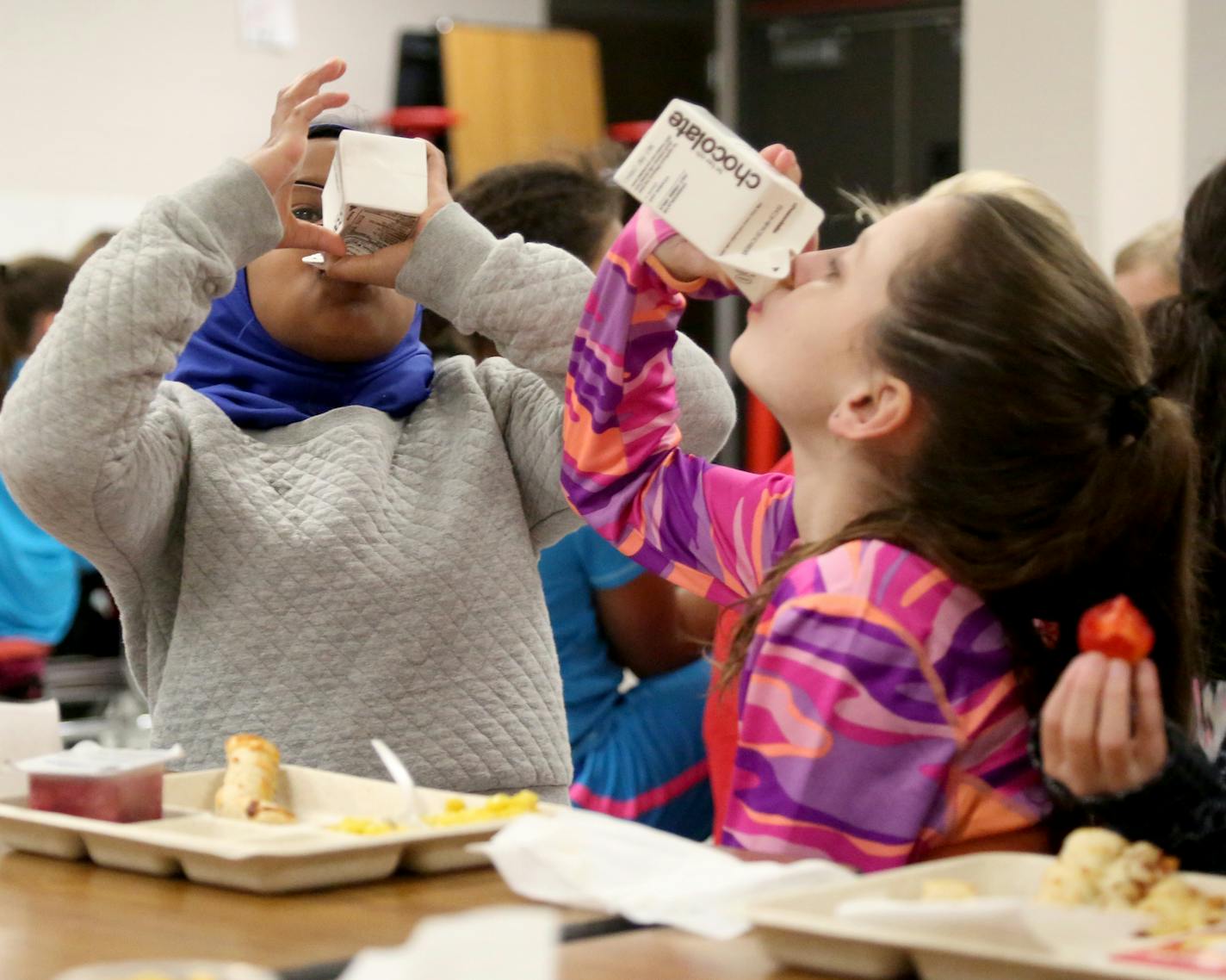 Sioux Trail Elementary third-graders, Salma Omar, left, and Marriana Ristamaki-McKee tried to drink their milk.