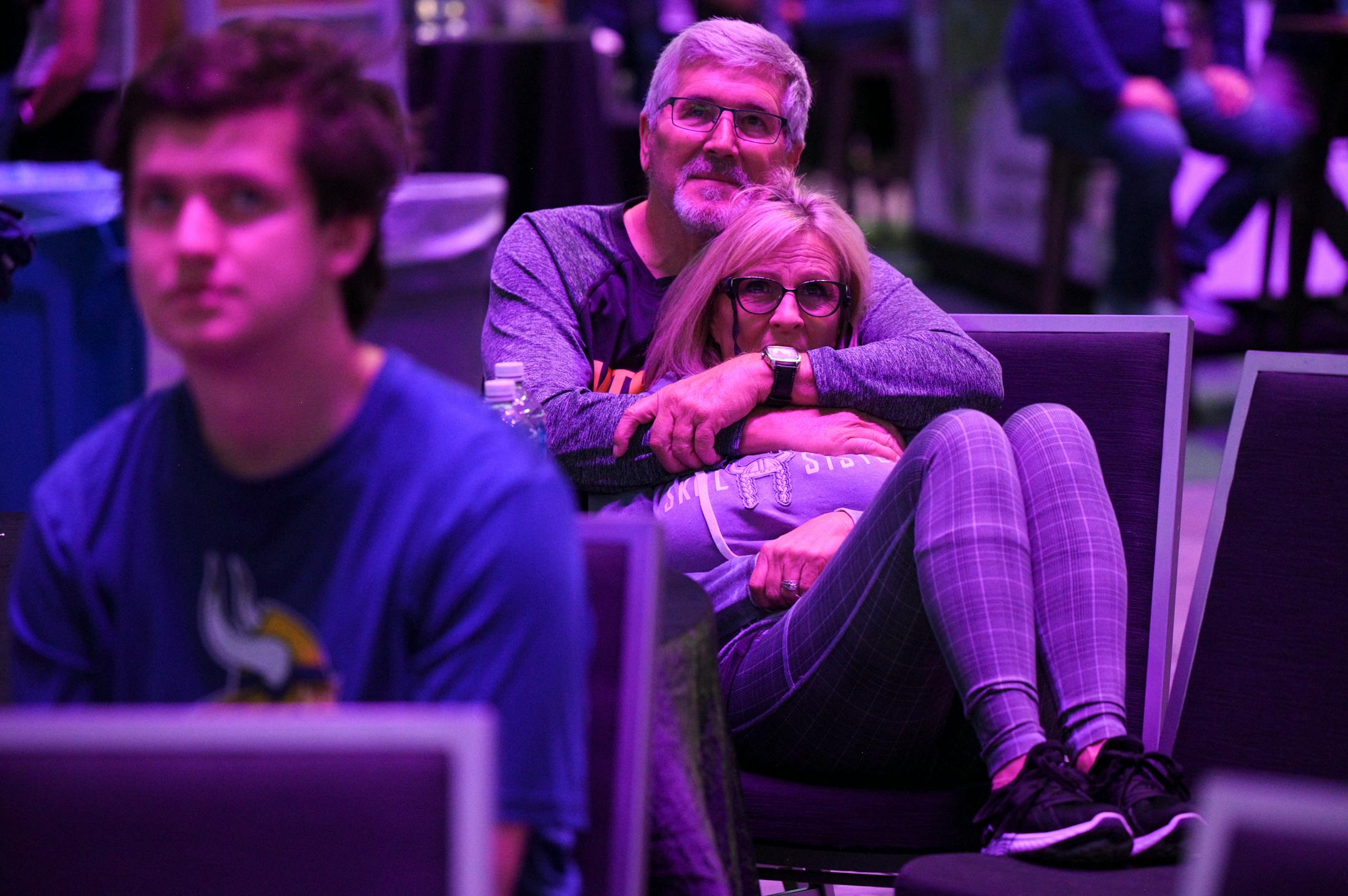 Settling in for the long night ahead, Wendy Bitting, of Myrtle Beach, rests in the arms of her husband, Linc, a lifelong Vikings fan, during the Vikings NFL Draft Party.