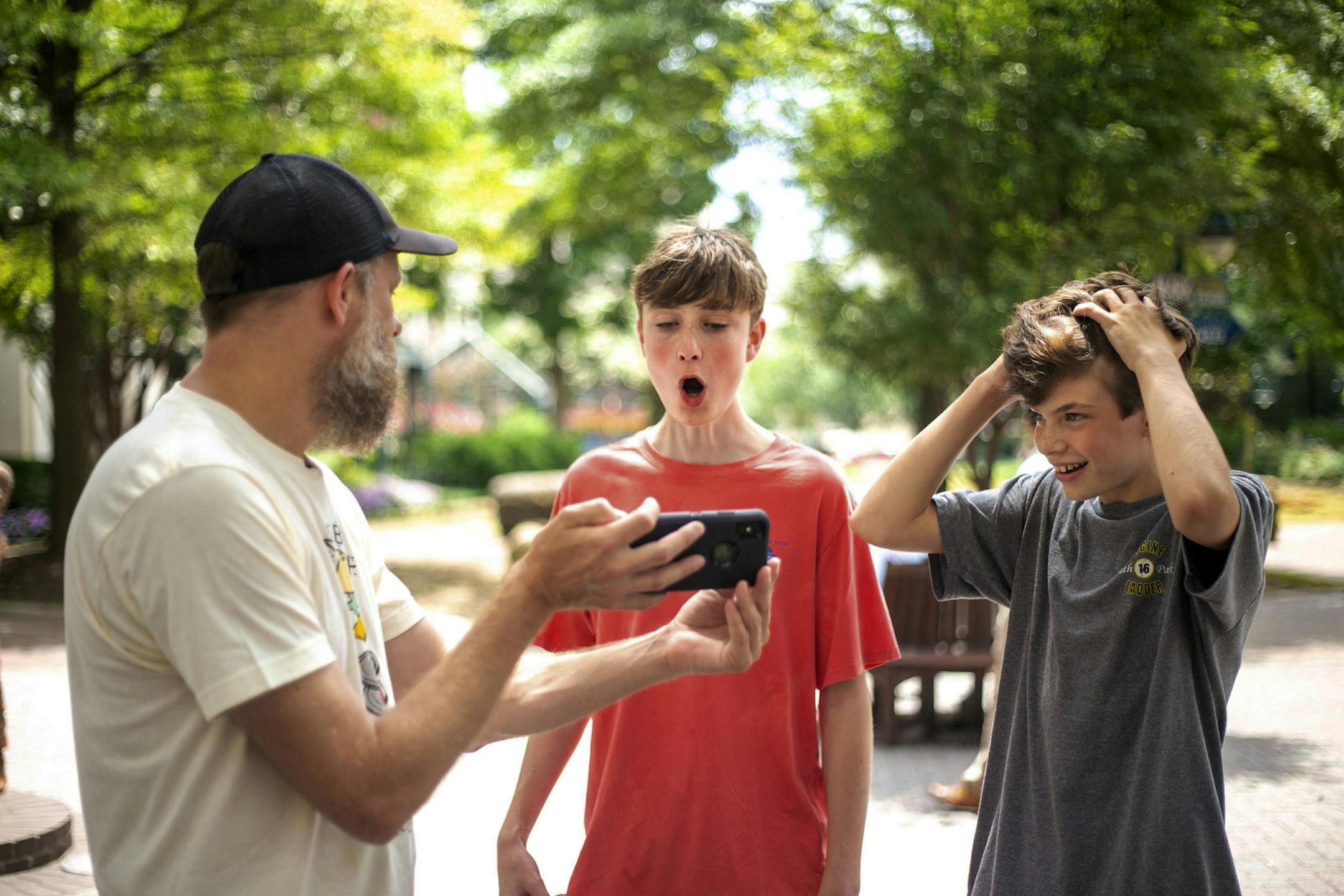 In a Sunday, July 10, 2019 photo, John Austin, left, who has a talent of taking phrases and saying the words in reverse, gets a reaction from Henry Stuart, center, 14, and Tommy Hawthorne, 13, after saying a phrase they requested in Charlotte. (Joshua Komer/The Charlotte Observer via AP)