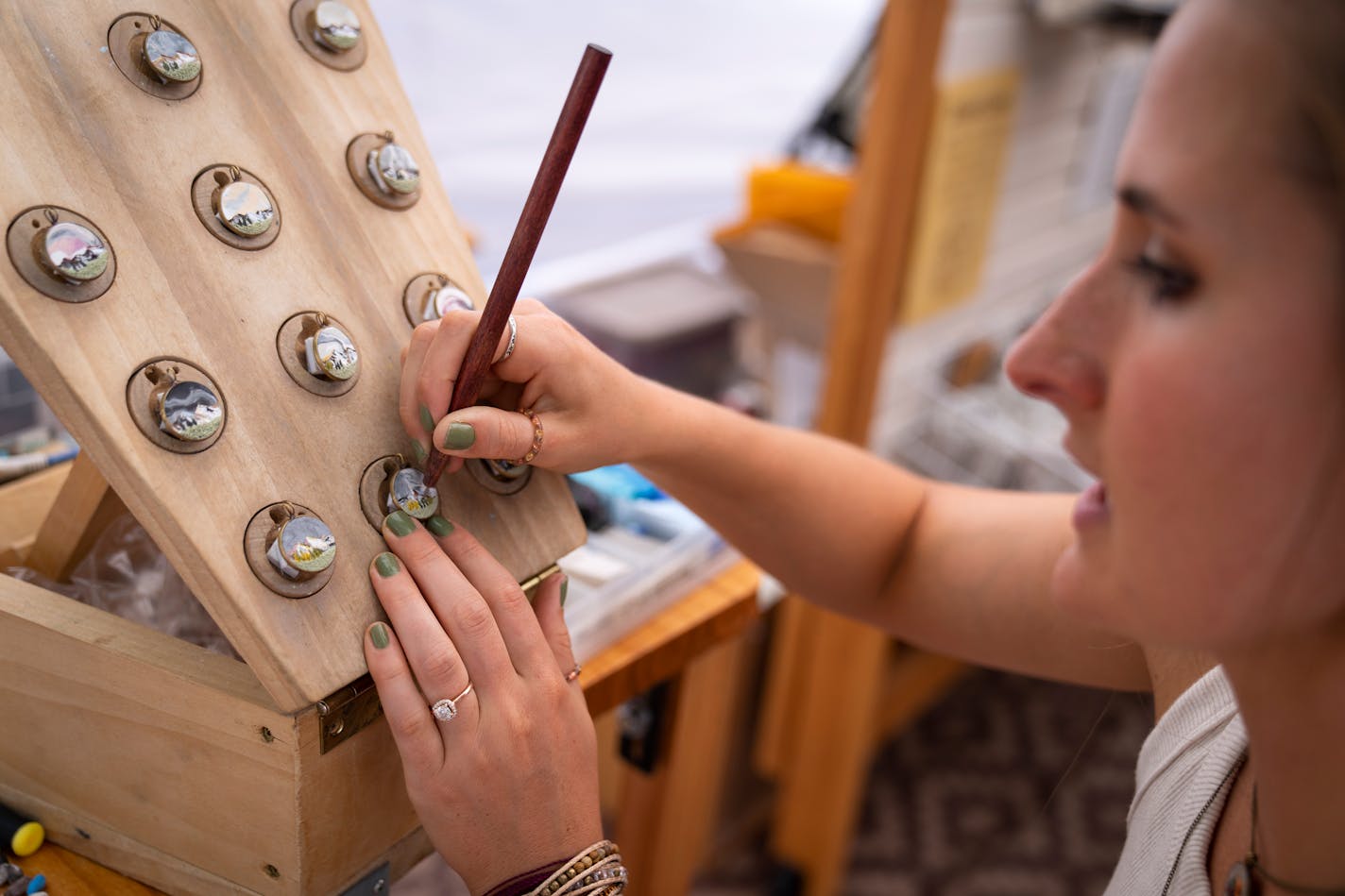 Grace Vanderbush of Earth Clay demonstrates how she makes her tiny clay pendant necklaces representing landscapes of National Parks.